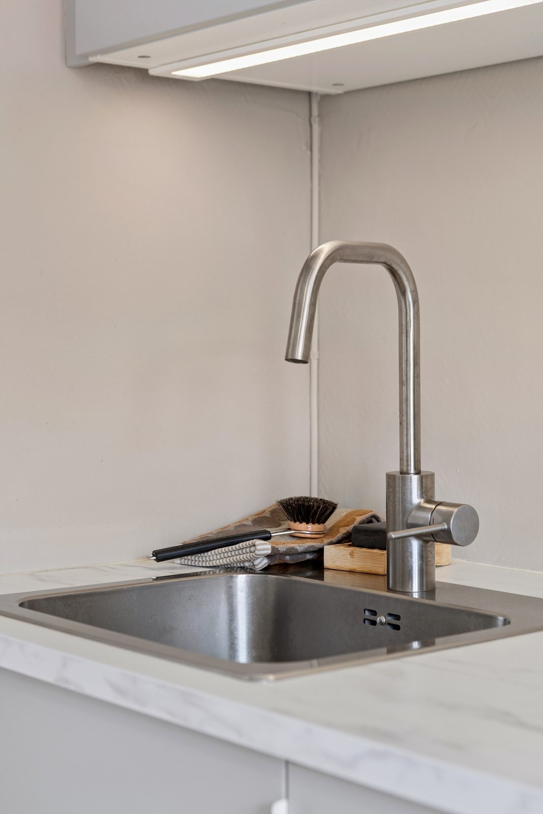 Detaljer fra kjøkken med stilrent design og moderne armatur. Galleribilde