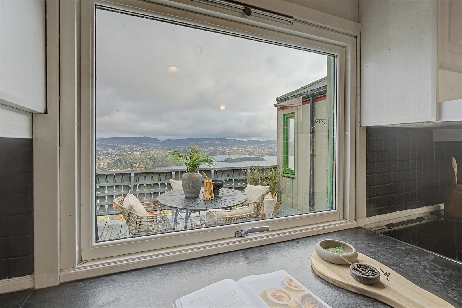 Fra kjøkkenbenken kan du nyte utsikten og holde kontakt med spisebordet på altanen. Galleribilde