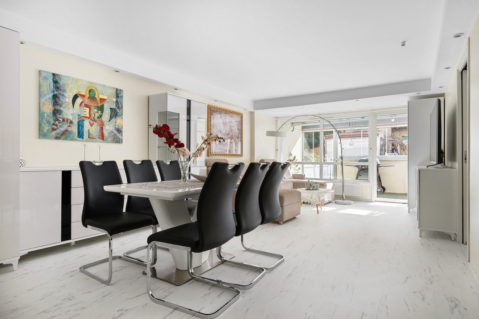 Lys og romslig stue med store vindusflater som slipper inn rikelig med dagslys, god plass til både sofagruppe og spisebord, og direkte utgang til den innglassede terrasen. Galleribilde