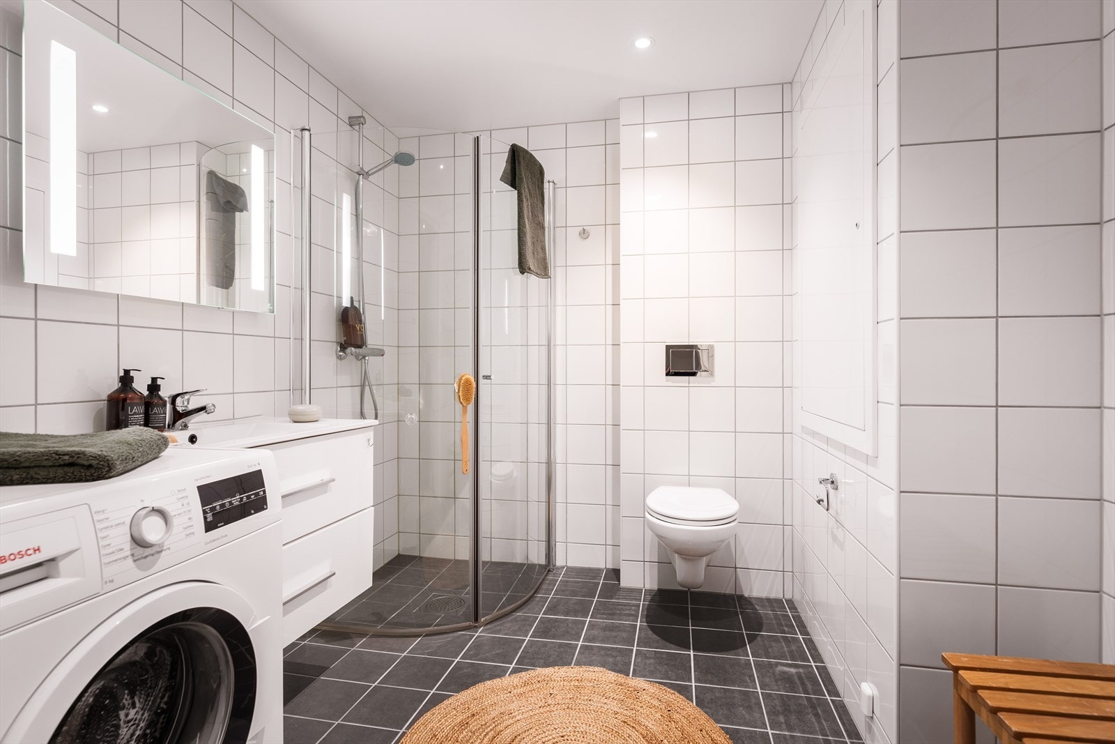 Stilrent baderom med klassiske fliser, vannbåren gulvvarme og en gjennomført, moderne finish. Galleribilde