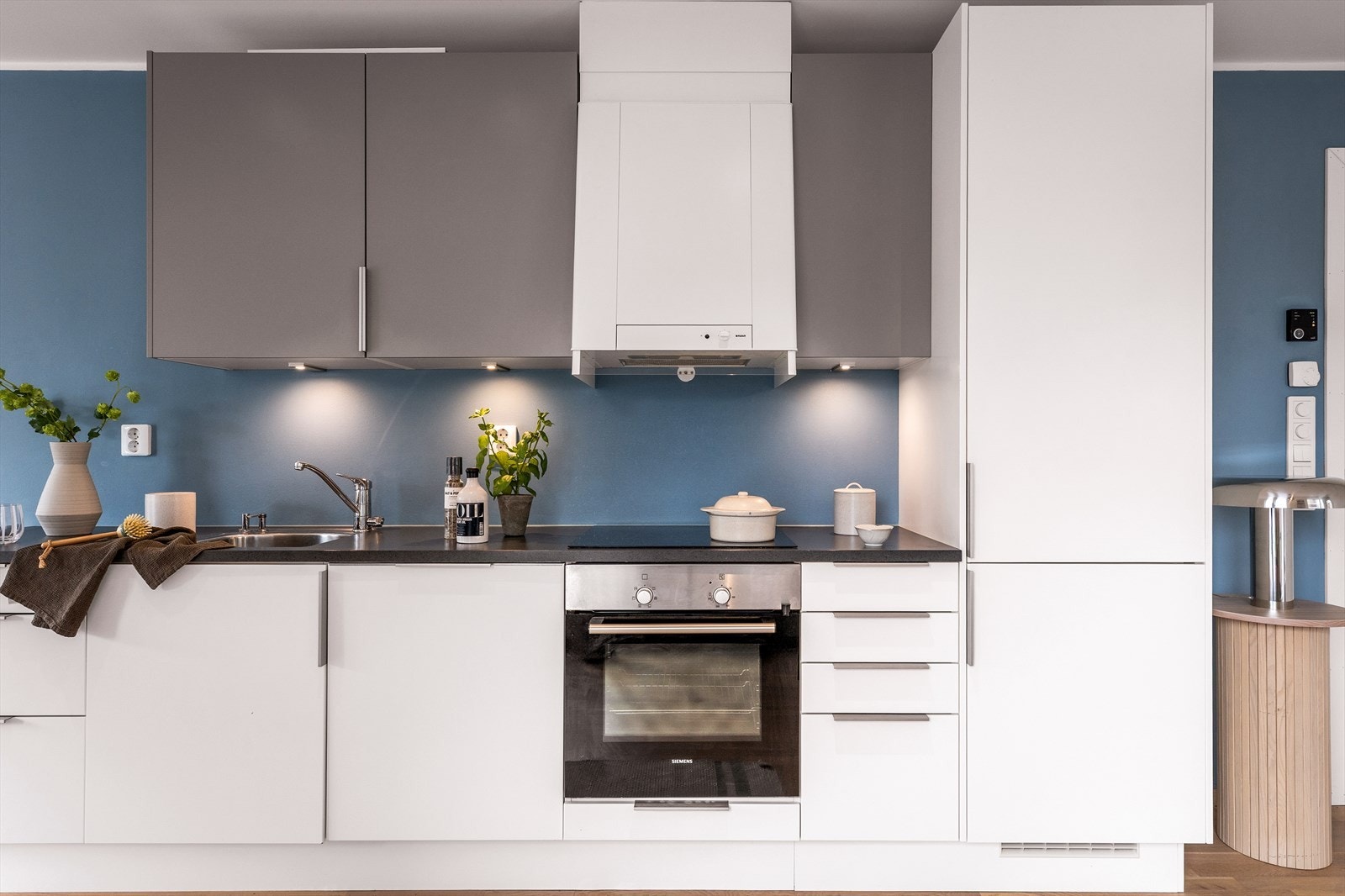 Tidløs kjøkkeninnredning fra kvalitetsleverandøren Sigdal med glatte fronter og laminert benkeplate. Galleribilde