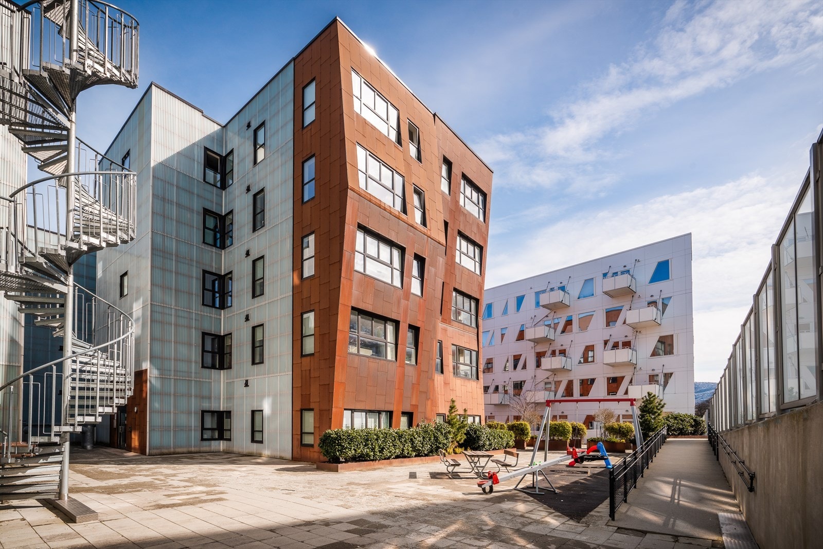 Fellesarealet er pent opparbeidet med beplantning, felles utemøbler og lekeareal. Galleribilde