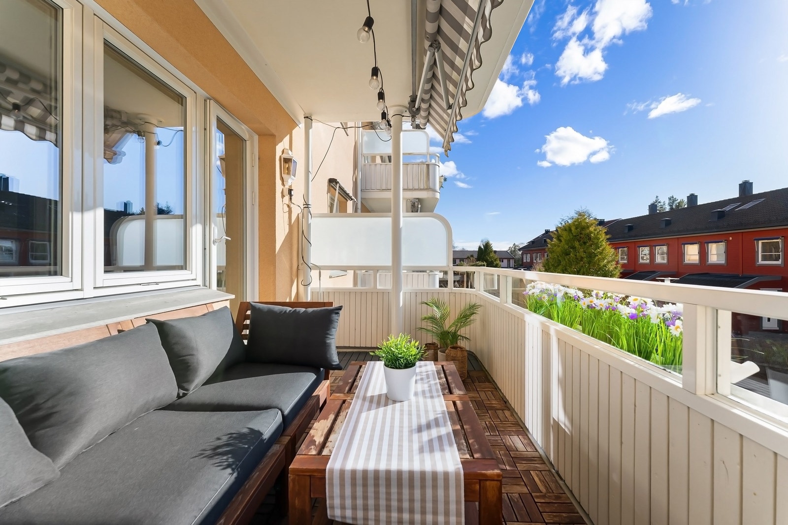 Balkongen er belagt med terrasseheller og har et rekkverk av tre. Galleribilde