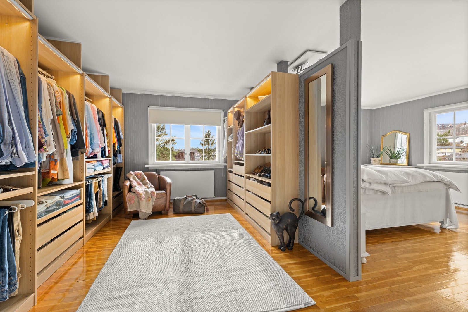 Praktisk garderom/walk-in closet med gode oppbevaringsløsninger og vindu som gir naturlig lys. Galleribilde