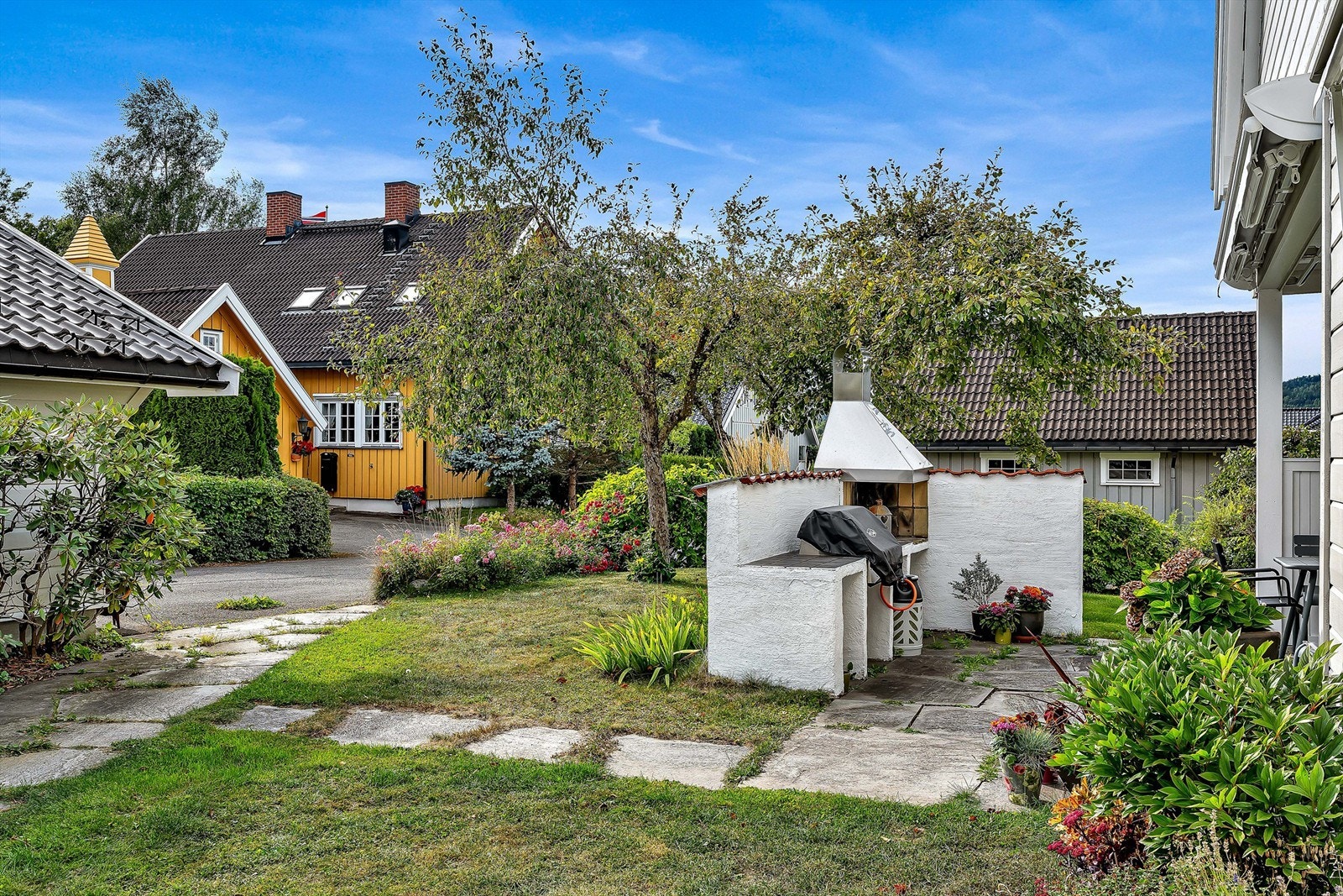 Hagen er pent opparbeidet med plen, beplantning og frukttrær (epler og plommer, samt ripsbusker) Galleribilde