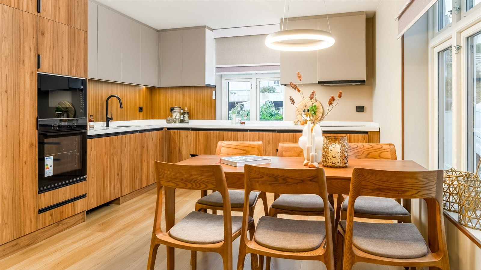 Kjøkkenet er delikat innredet med en kombinasjon av trefargede og lyse, slette fronter og hvit benkeplate i kompositt. Et stort og godt kjøkken som gir rikelig med lagringsplass, samt gode arbeidsplasser på benk. Galleribilde