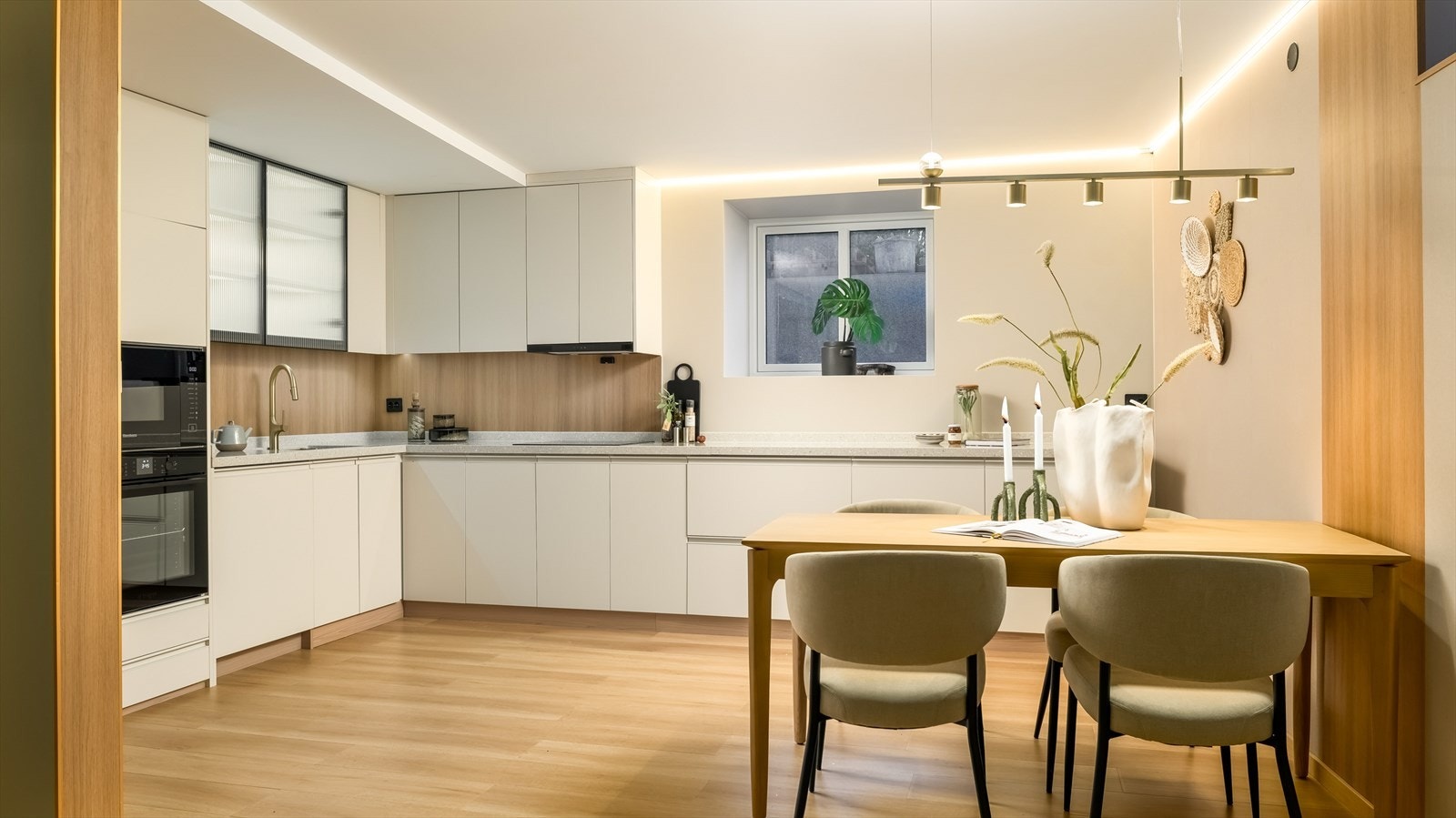 Kjøkkenet er stilrent innredet med lyse, slette fronter og grå benkeplate i solid og eksklusiv kompositt. Her får man gode arbeidsflater på benk og god lagringsplass i skap- og skuffer. Galleribilde