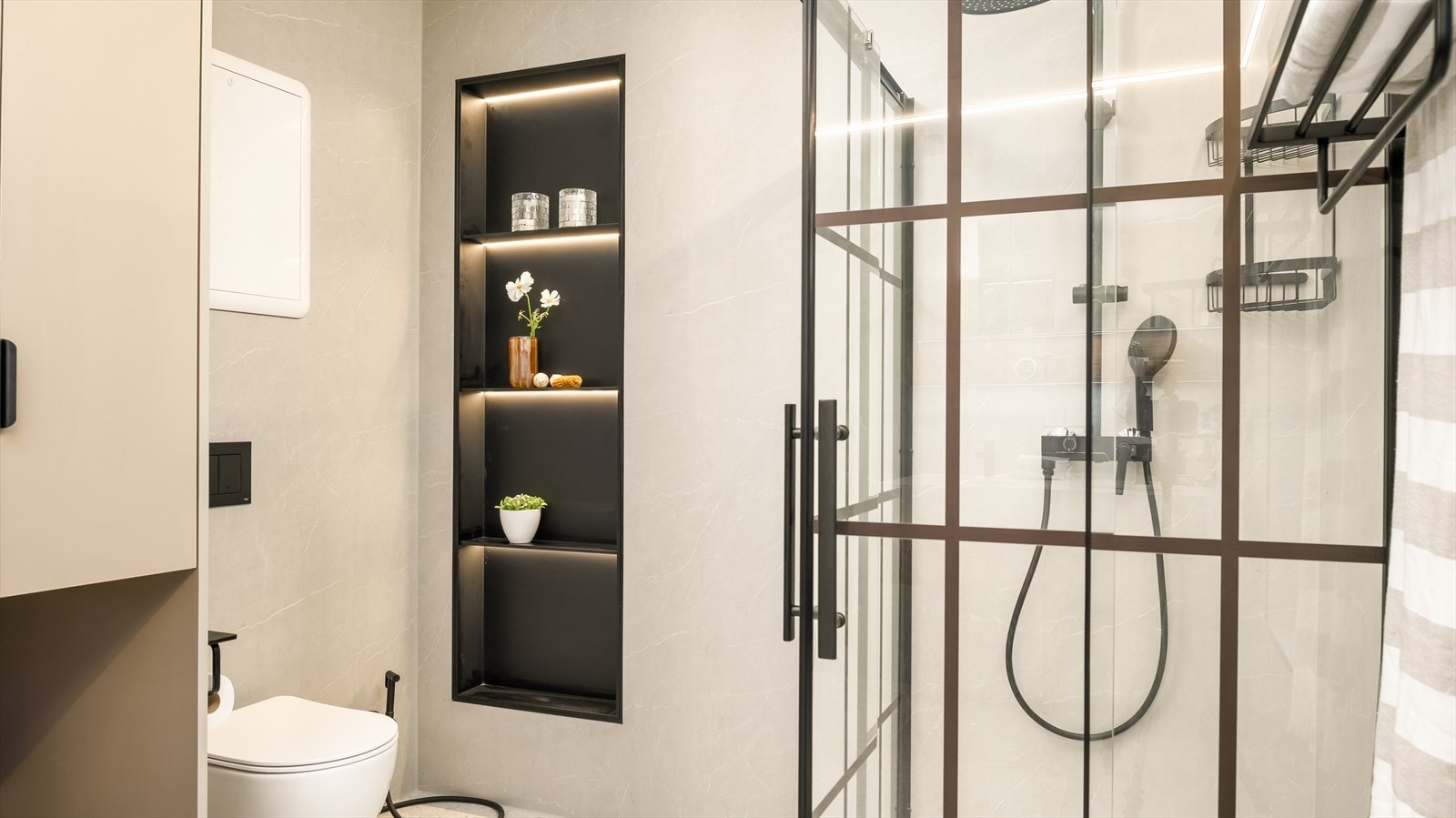 Badet er stilrent innredet med grå fliser på gulvet og grå baderomsplater på vegg. I gulvet har man også varmekabler for ekstra komfort. Galleribilde