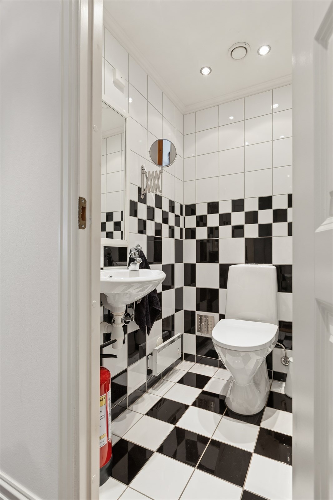 Separat wc-rom med gulvstående toalett og enkel servantinnredning på vegg. Galleribilde