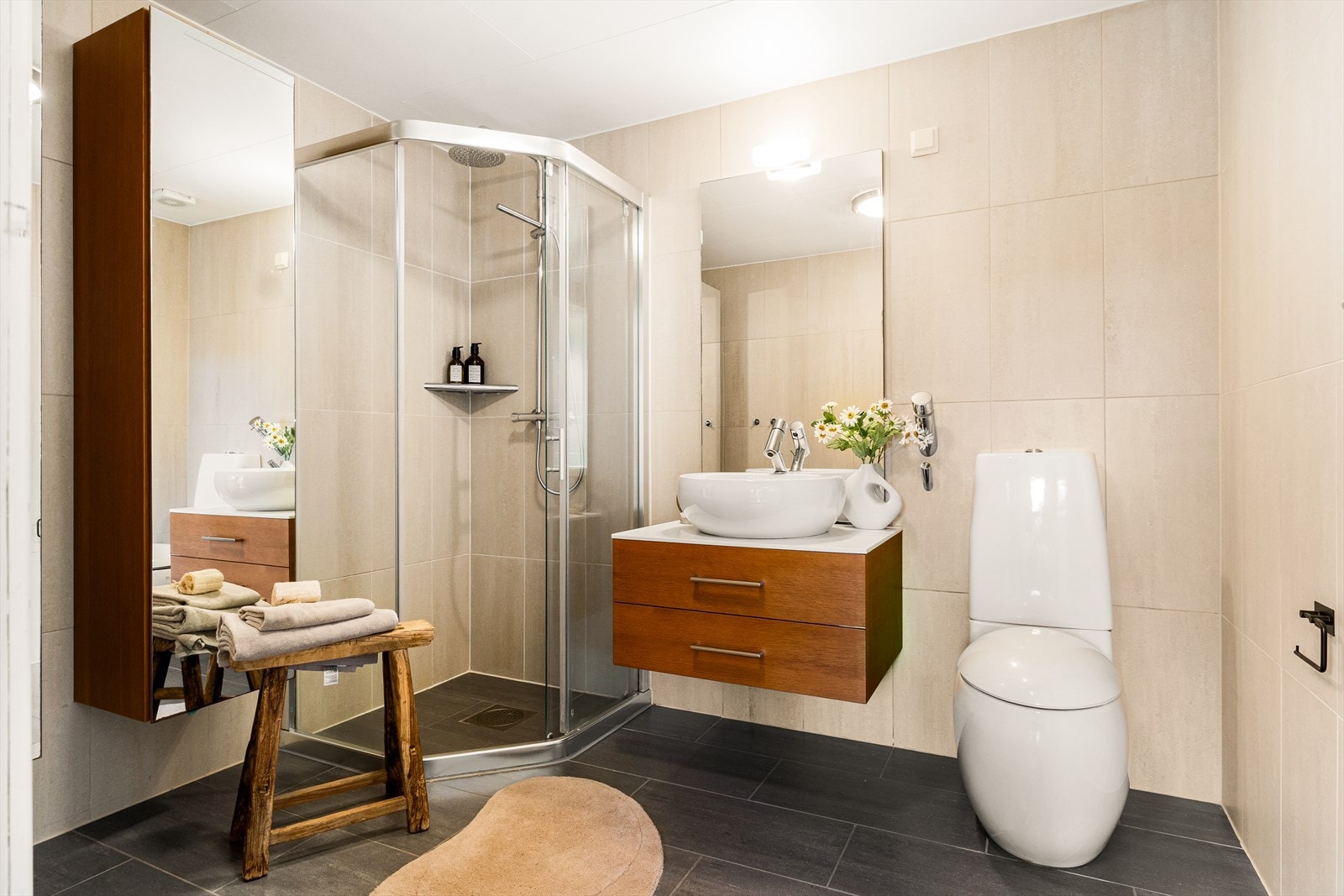 Badet har varmekabler i gulvet og er integrert med vegghengt toalett, servant og dusj. Galleribilde