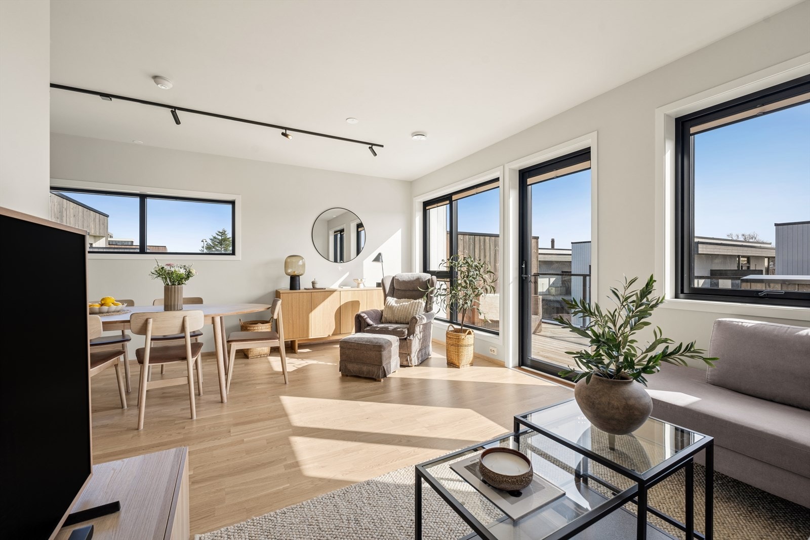 Den åpne stue- og kjøkkenløsningen har gjennomgående parkettgulv og store vindusflater med 3-lags glass. Galleribilde