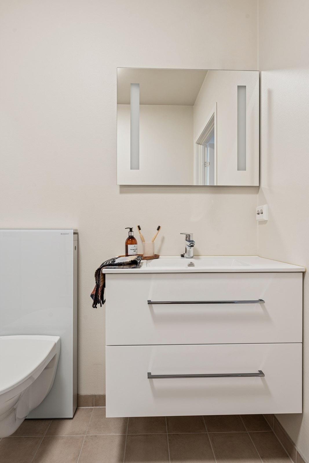 Badet er utstyrt med innredning med nedfelt servant og et back-to-wall toalett med Geberit Monolith sisterne. Galleribilde