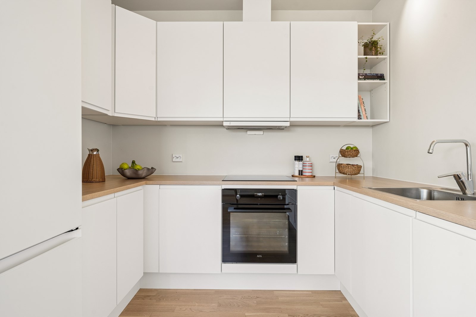 Kjøkkeninnredningen har glatte fronter og er utstyrt med integrert oppvaskmaskin, induksjonstopp og stekeovn. Galleribilde