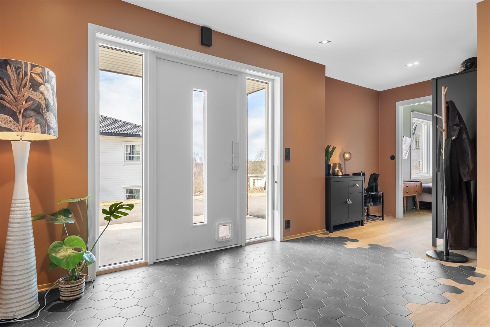 Innbydende entré med god plass, lekre materialvalg og store dører som slipper lyset flott inn. Galleribilde