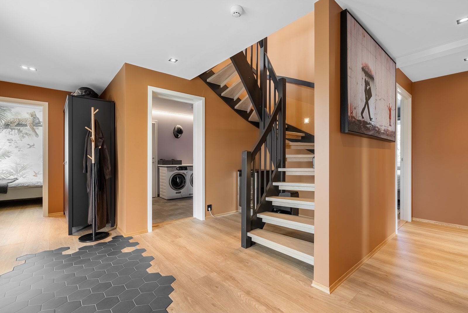 Lys og romslig hall med moderne trappeløsning og praktisk tilgang til både soverom og vaskerom. Galleribilde