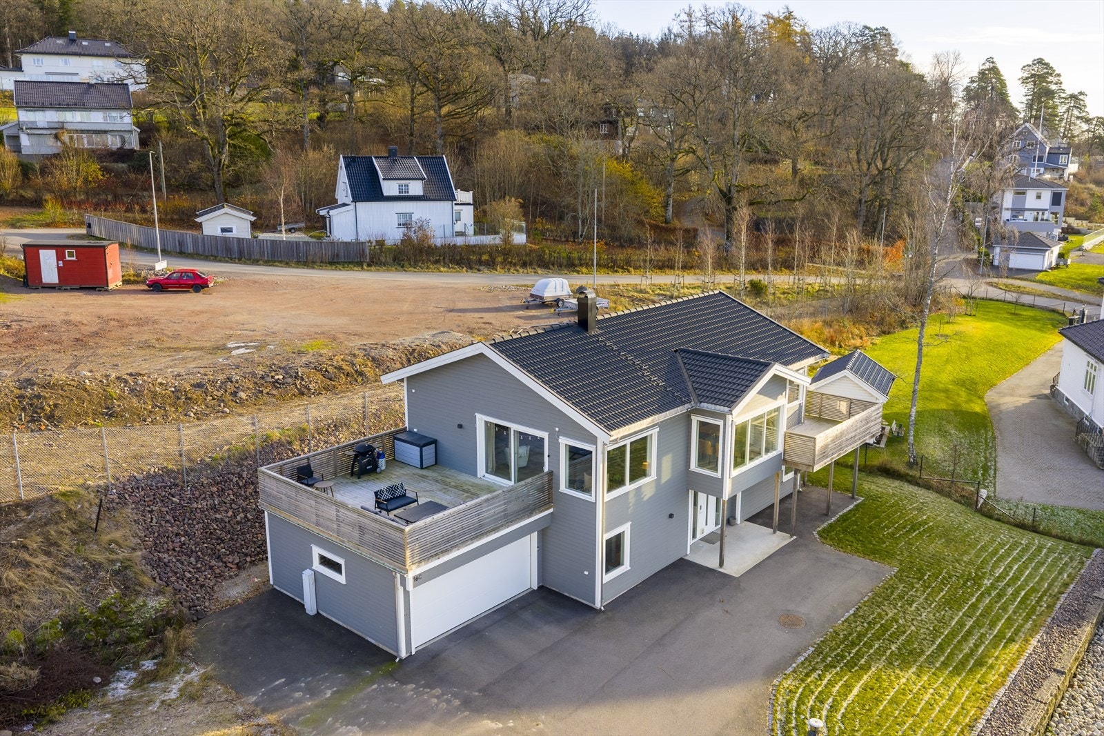 Moderne fasade med stor terrasse over garasjen og gode solforhold. Galleribilde