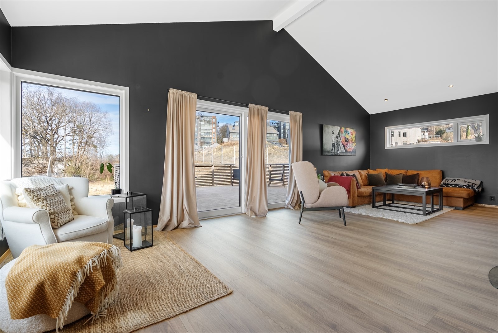 Romslig og lyst oppholdsrom med store vinduer, moderne fargevalg og direkte utgang til terrasse. Galleribilde