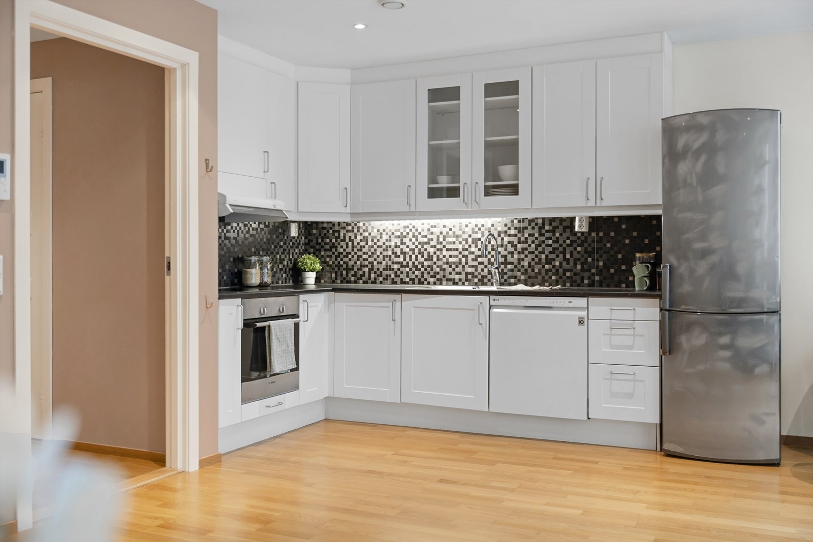 Hvit, tidløs kjøkkeninnredning fra Designa med profilerte fronter. Galleribilde