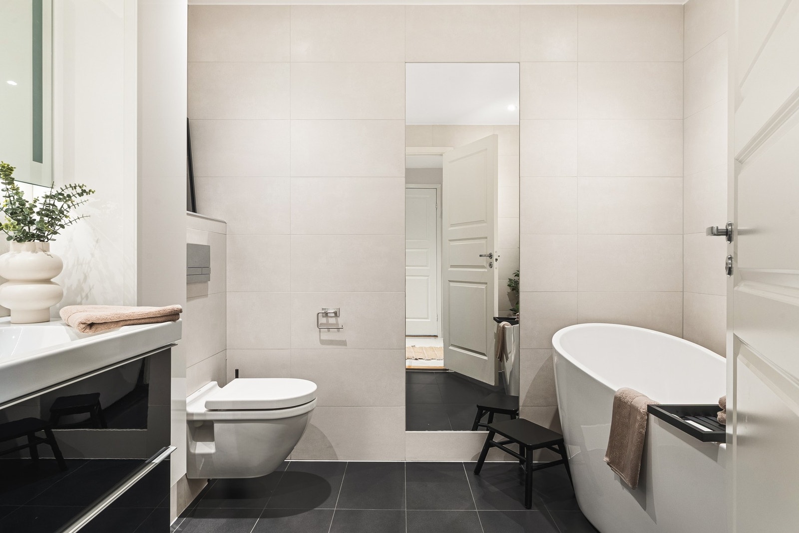 Det romslige badet i 1. etasje på 5,7 kvm er helfliset med varmekabler i gulv og innfelte downlights i tak. Galleribilde