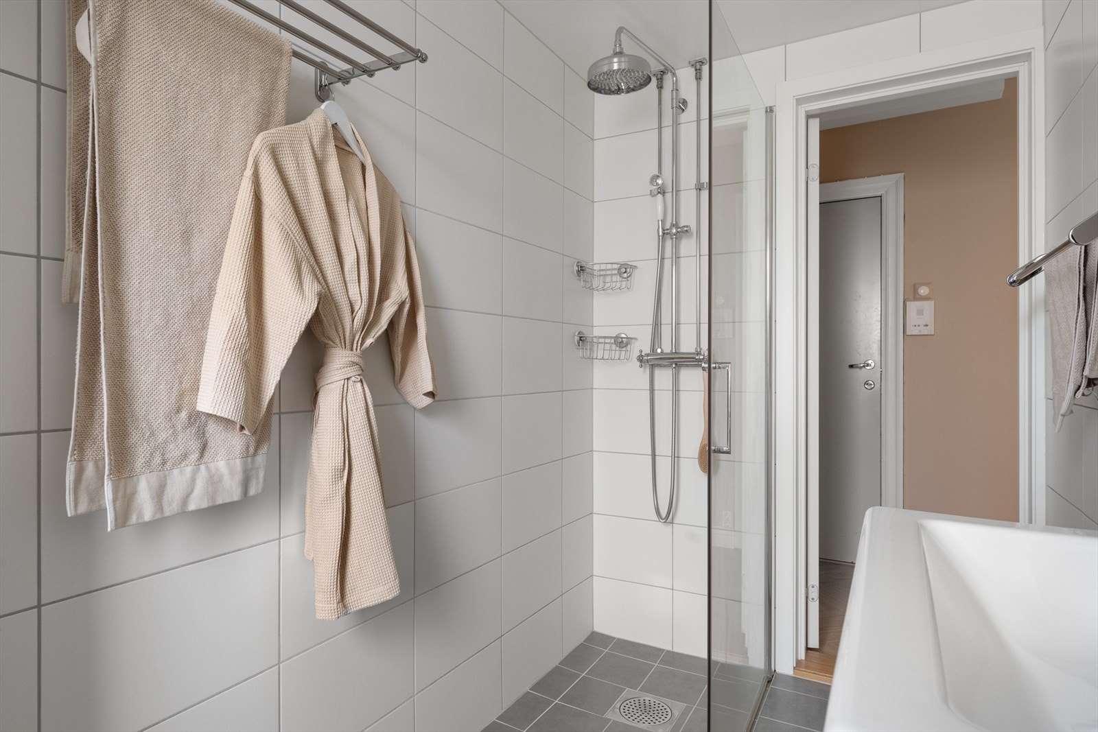 - Badet inneholder vegghengt toalett, benkeskap med servant, dusjdører i glass og fordelerskap til rør i rør vannforsyning - Galleribilde