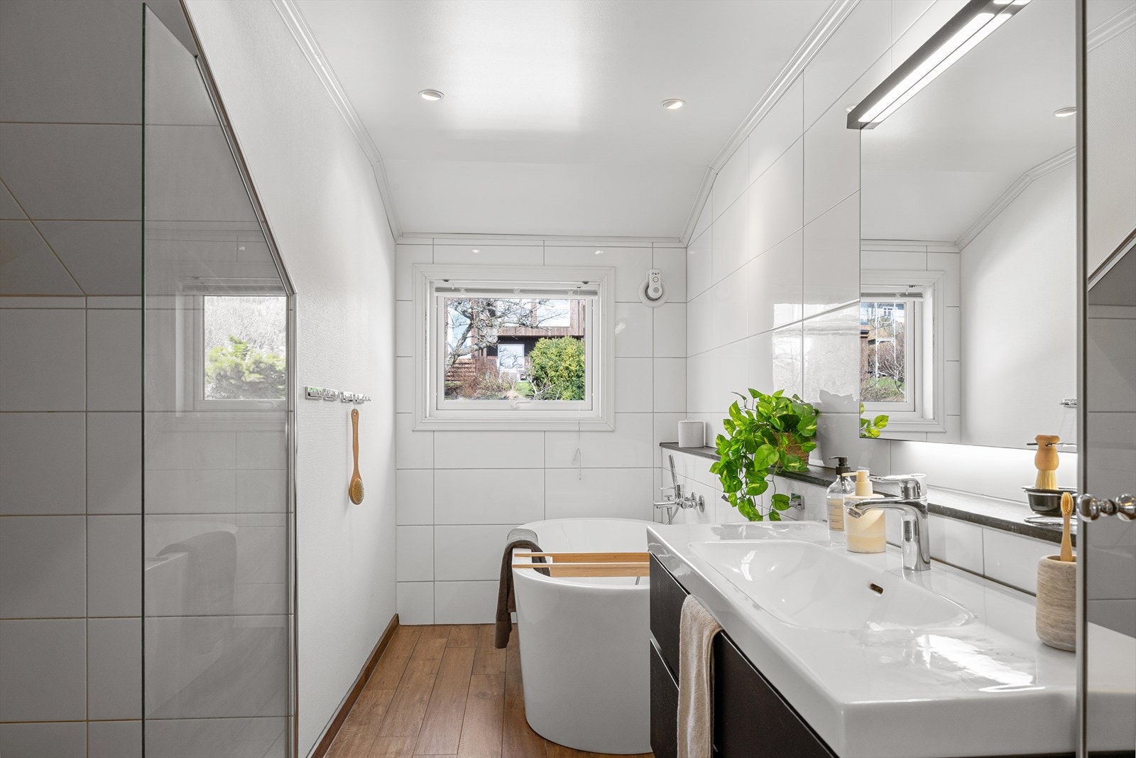 Smakfullt bad fra 2015 med fliser og varmekabler, samt både badekar og god dusjnisje Galleribilde