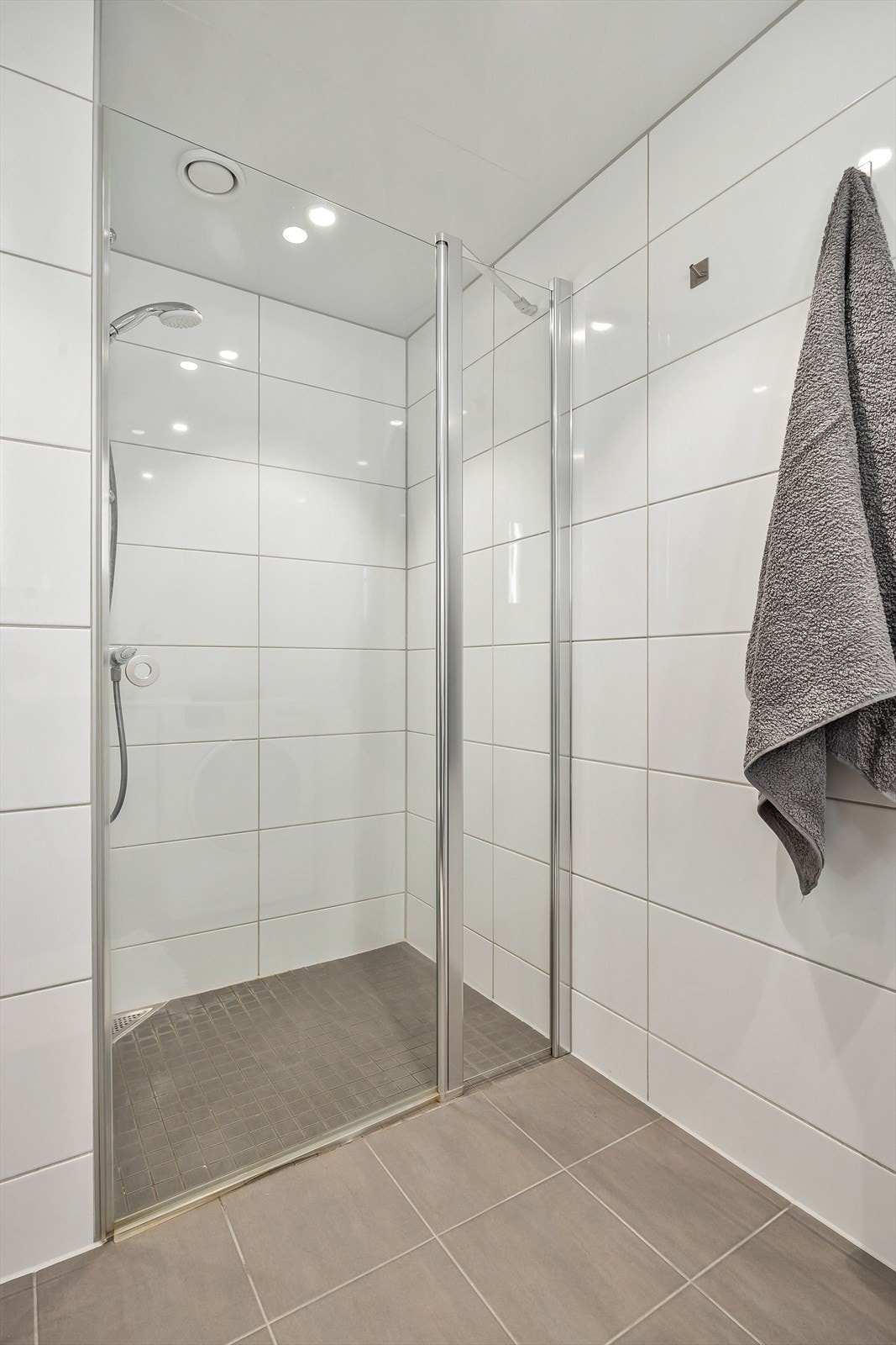 Badet har dusjnisje med dusjvegg-/dør av glass samt vegghengt dusjarmatur. Galleribilde