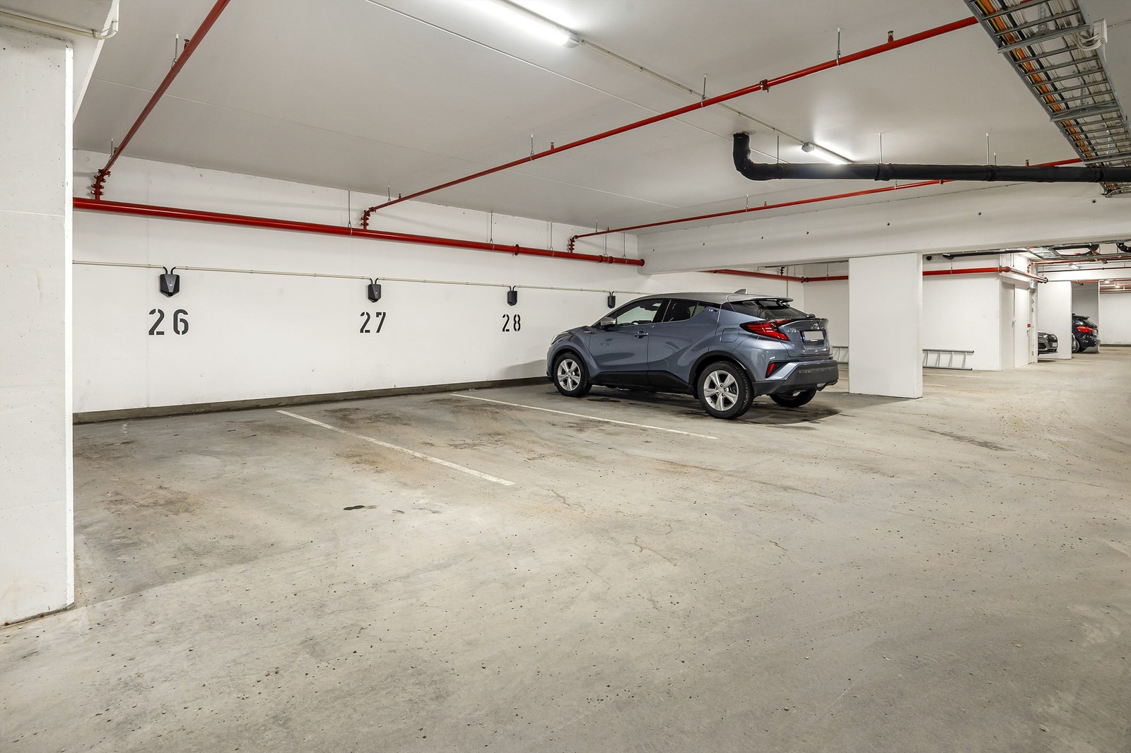 Medfølgende disponibel parkeringsplass (nr. 27 iflg. selger) med el-billader i felles garasjeanlegg. Galleribilde