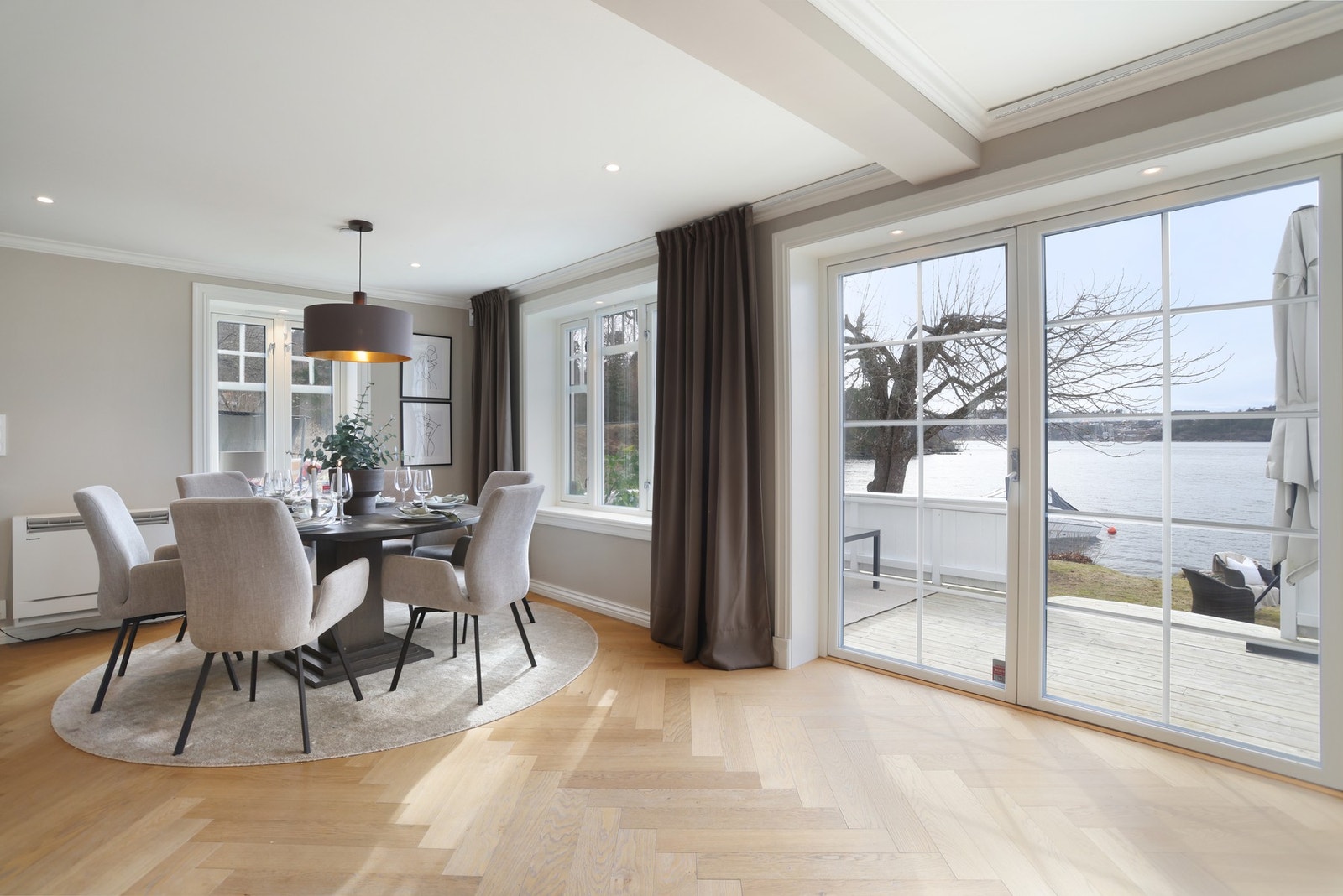 Utgang til solfylt terrasse og strandlinje fra spisetue/stue Galleribilde
