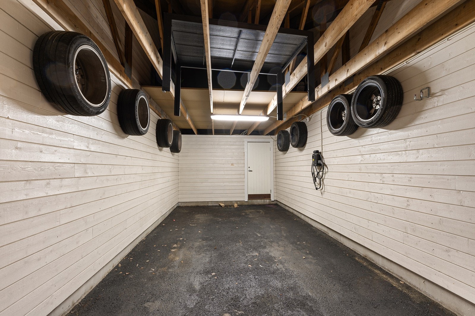 Carporten har nylig fått ny asfalt, og det er klargjort for installasjon av elbillader. Galleribilde