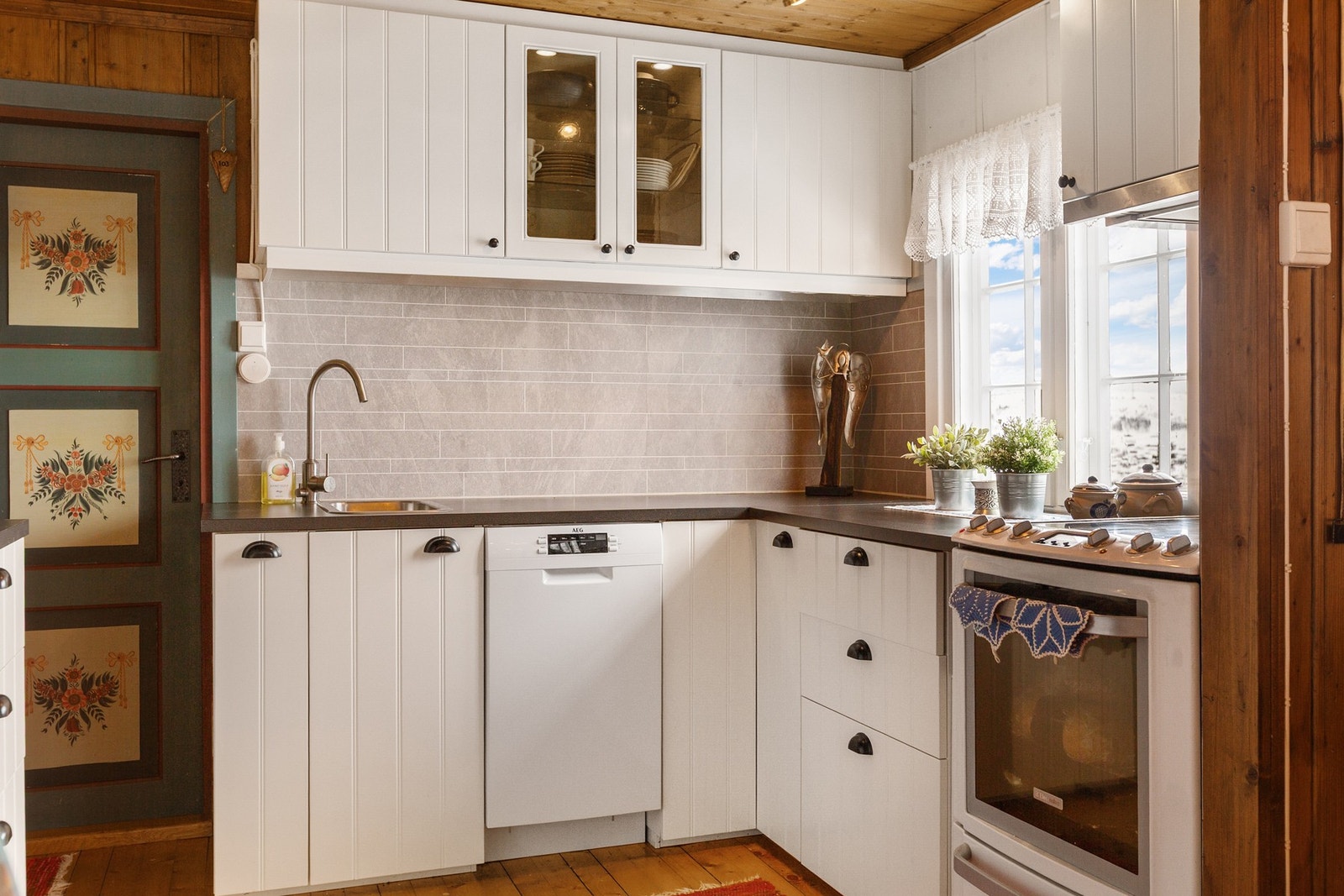 Lys kjøkkeninnredning med over- og underskap. Galleribilde