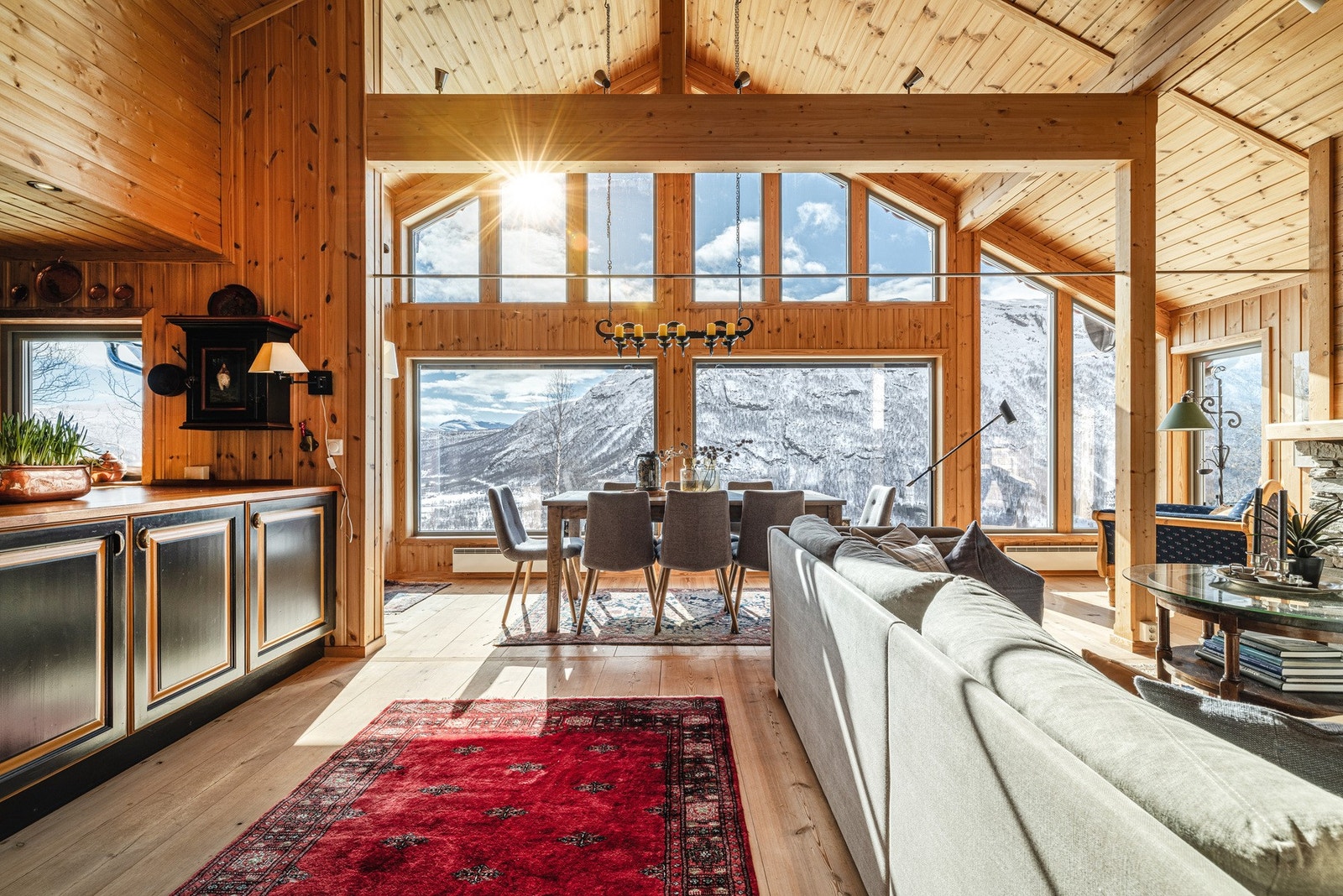 Oppholdsrommet er preget av store vinduer - her velter den mektige fjellformasjonen inn i oppholdsrommet! Galleribilde
