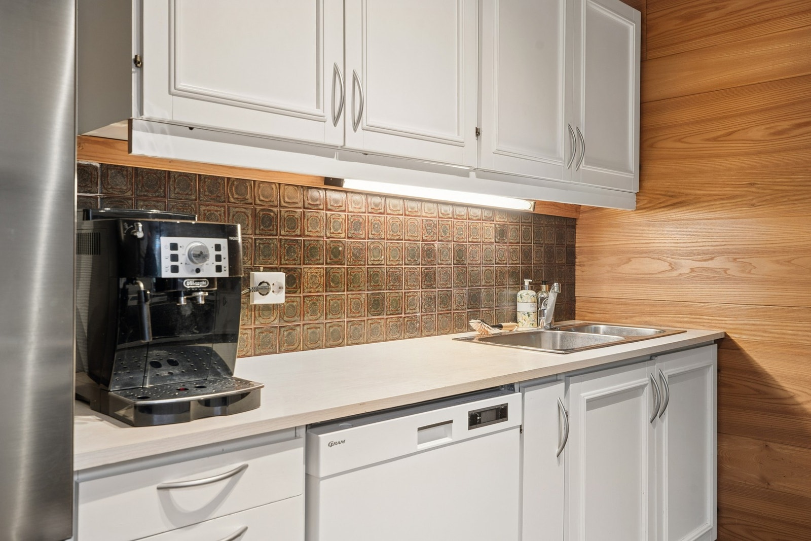 - Enkel kjøkkeninnredning med kjøleskap, oppvaskmaskin og vask - Galleribilde