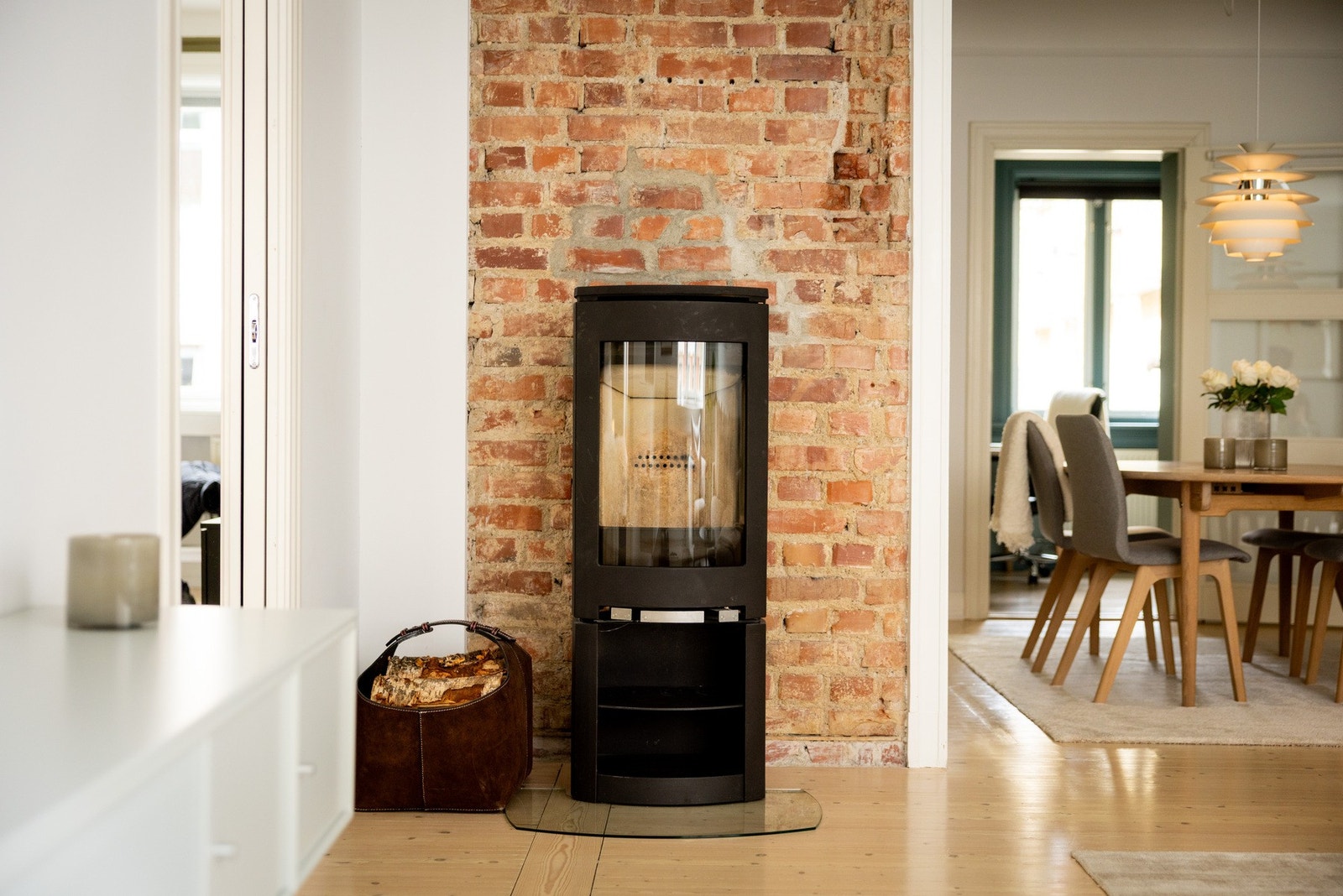 Peisovn fra Jøtul er plassert mot en teglsteinsvegg i stuen, noe som både gir god varme og tilfører rommet et særpreget og karakterfullt uttrykk. Galleribilde