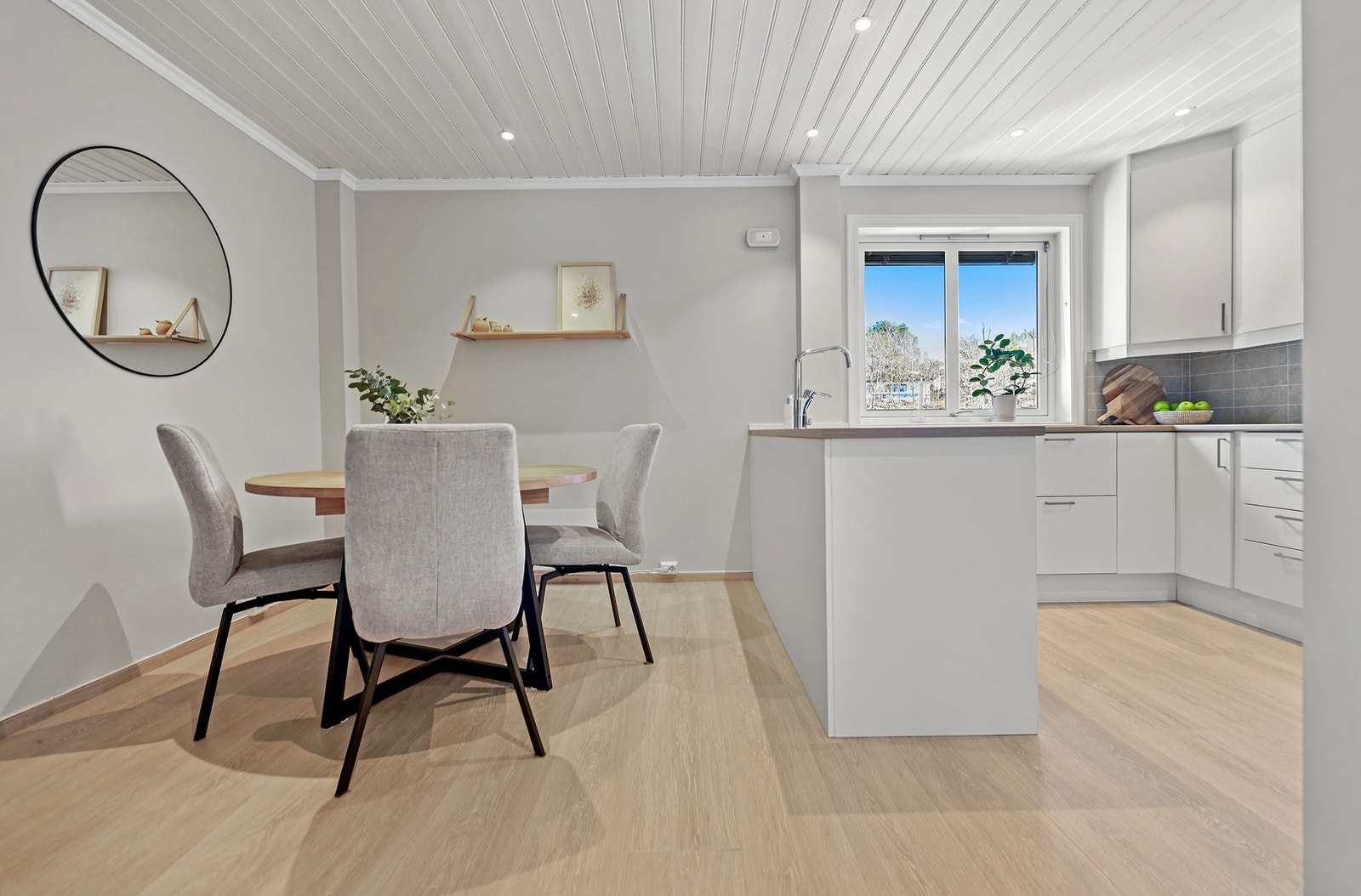 Det store kjøkkenet fremstår lyst og moderne, med en tidløs innredning i hvite, glatte fronter som gir et rent og ryddig uttrykk. Galleribilde