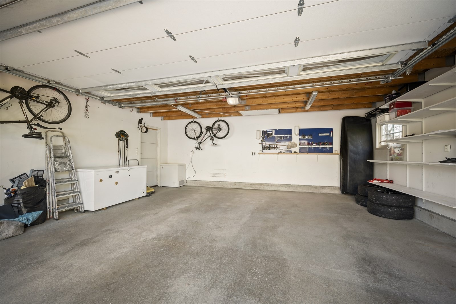 Garasjen gir praktisk oppbevaring av sykler, sportsutstyr og hageredskap, samtidig som bilene parkeres trygt og lett tilgjengelig. Galleribilde