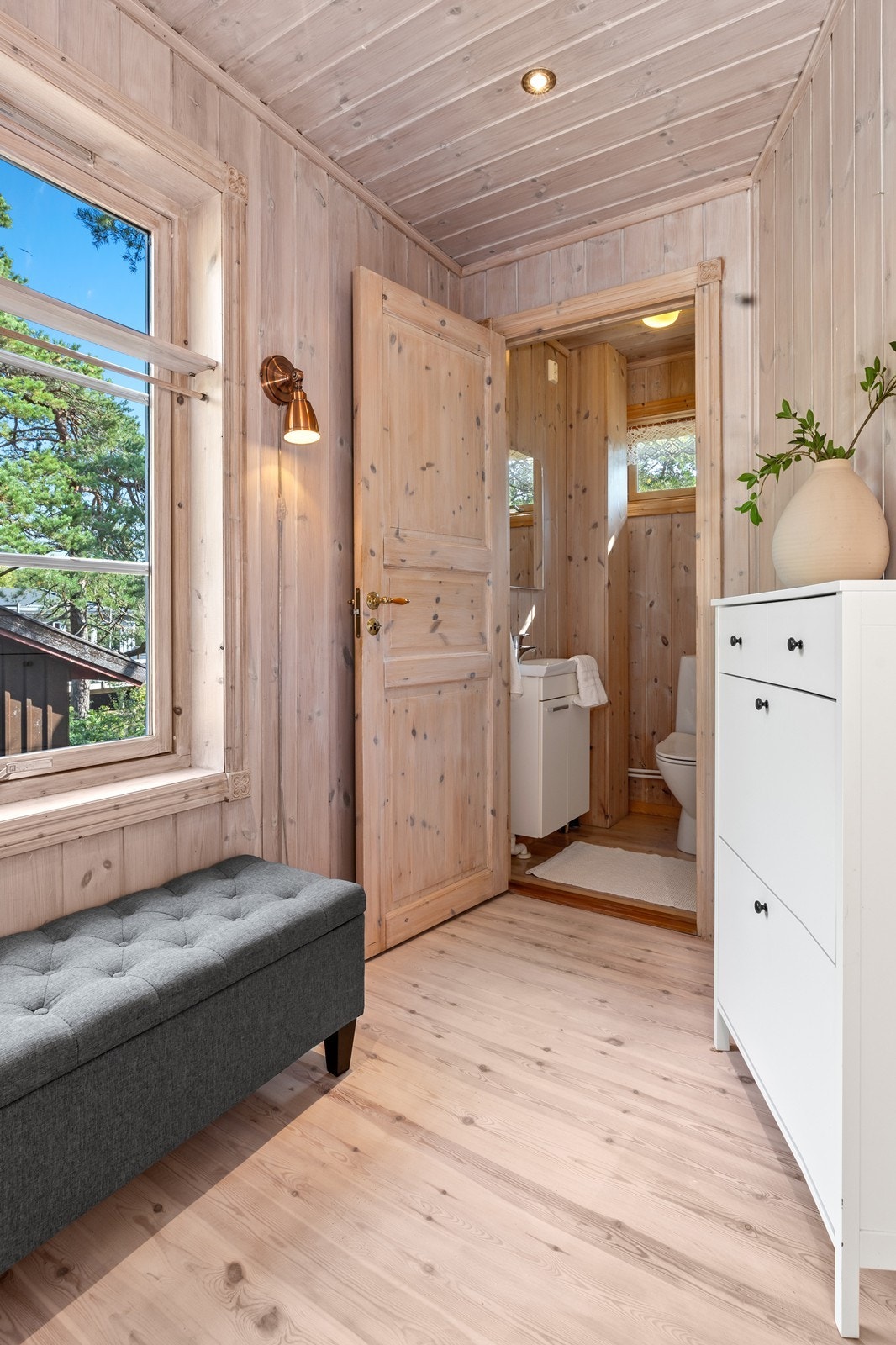 Det er separat toalettrom med panel på overflatene. Her er det gulvmontert toalett, i tillegg til en mindre skapinnredning med heldekkende servant med speil over Galleribilde