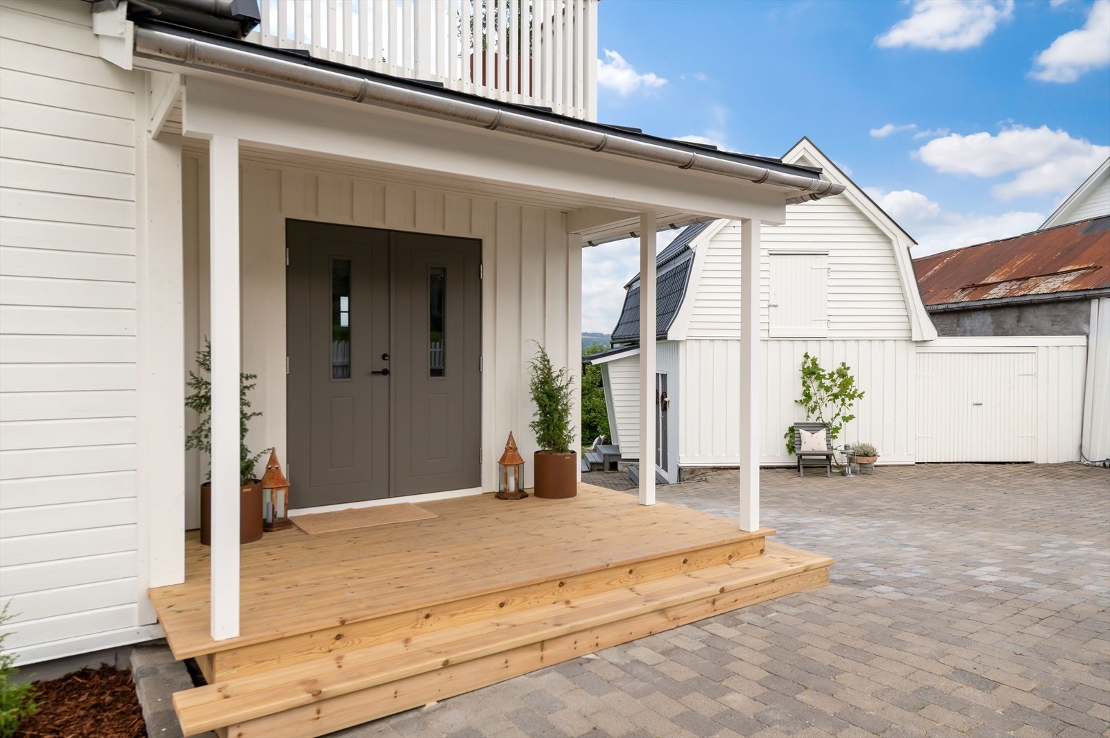 Villaen ønsker deg velkommen med et stilfullt inngangsparti. Den overbygde verandaen med trapp i tre gir et varmt og innbydende preg. Galleribilde