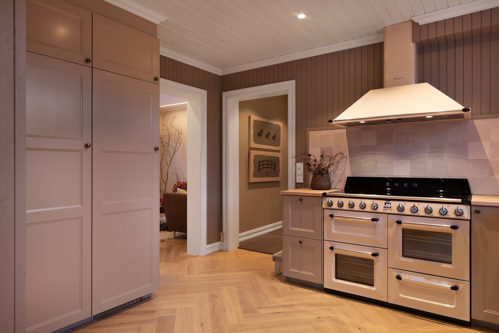 Kjøkkenet har en lekker og tidløs innredning med lyse, profilerte fronter og heltre benkeplate med nedfelt kjøkkenkum. Galleribilde