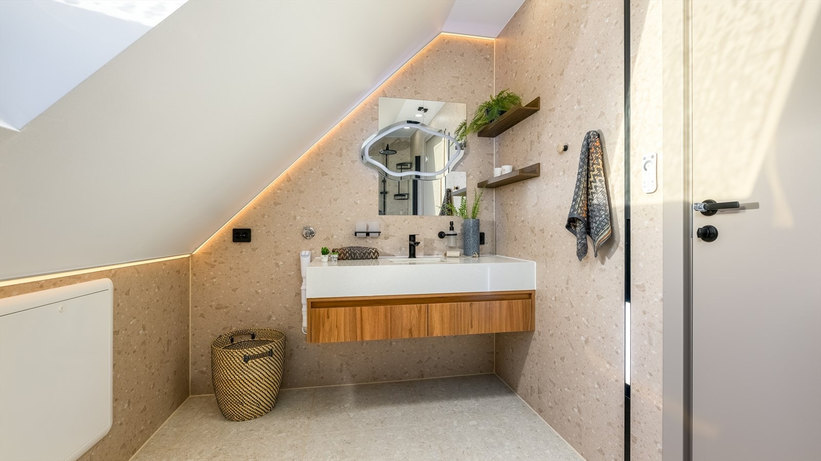 Badet er delikat innredet med store, grå fliser på gulvet og gråbeige baderomsplater på vegg. Også her har man varmekabler i gulvet. Galleribilde