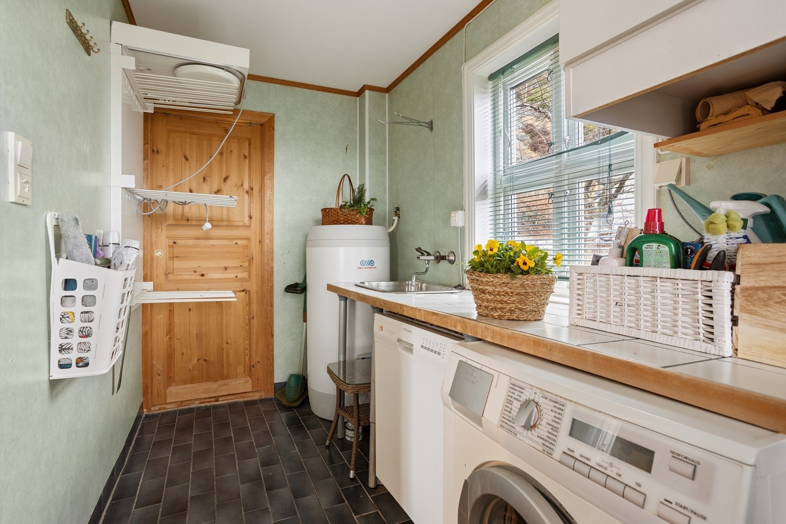 Separat vaskerom i første etasje med flislagt gulv og varmekabler. Rommet har utslagsvask og opplegg for vaskemaskin. Galleribilde