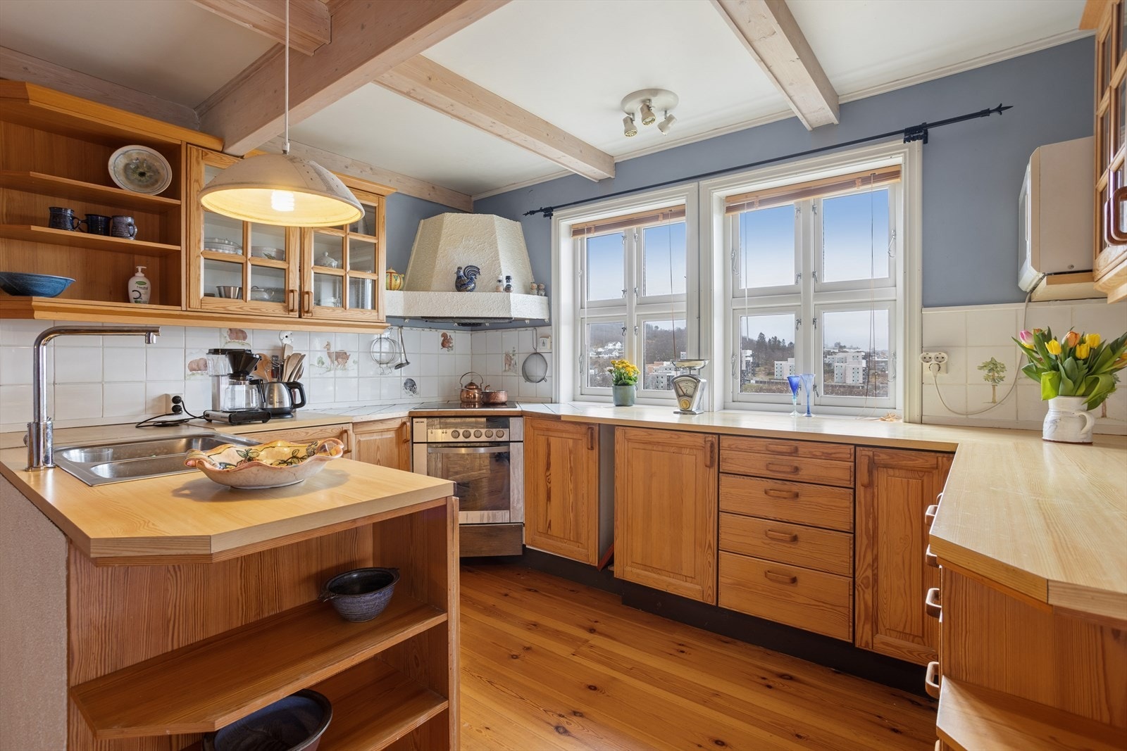 Kjøkkenet har en praktisk arbeidsøy og ventilator over platetoppen. Vinduene ble skiftet for cirka 10 år siden. Galleribilde