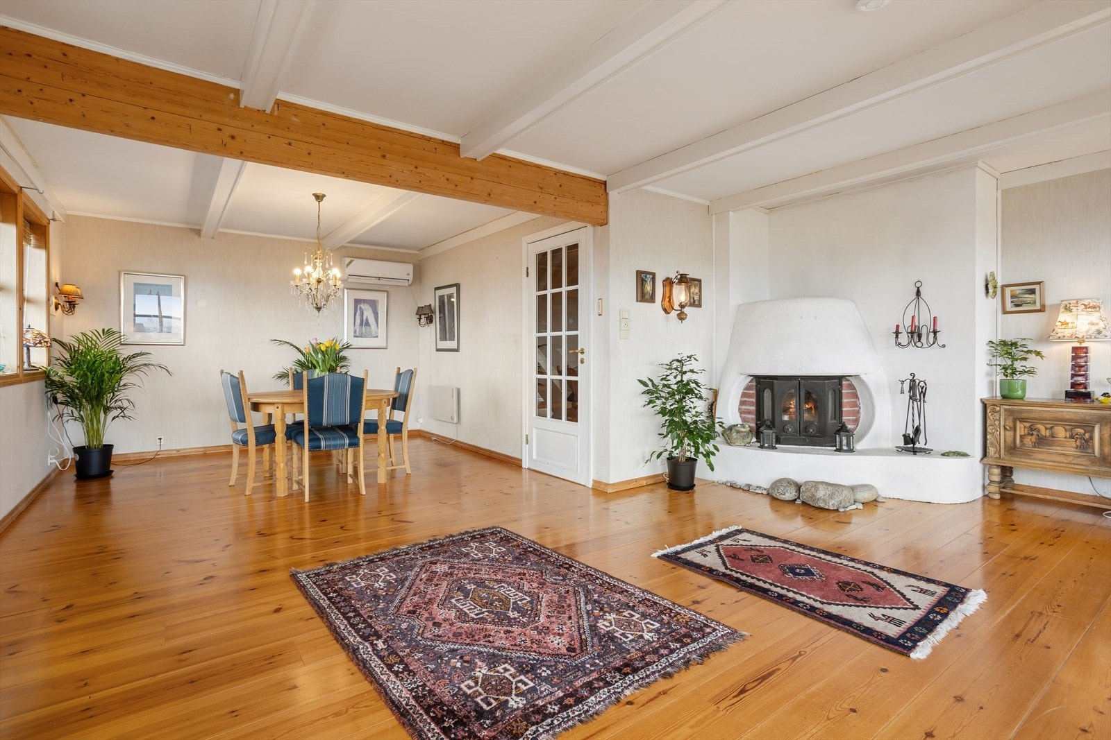 Stuen i første etasje har en stemningsfull peisinnsats som gir god varme. Rommet er lett å møblere. Galleribilde