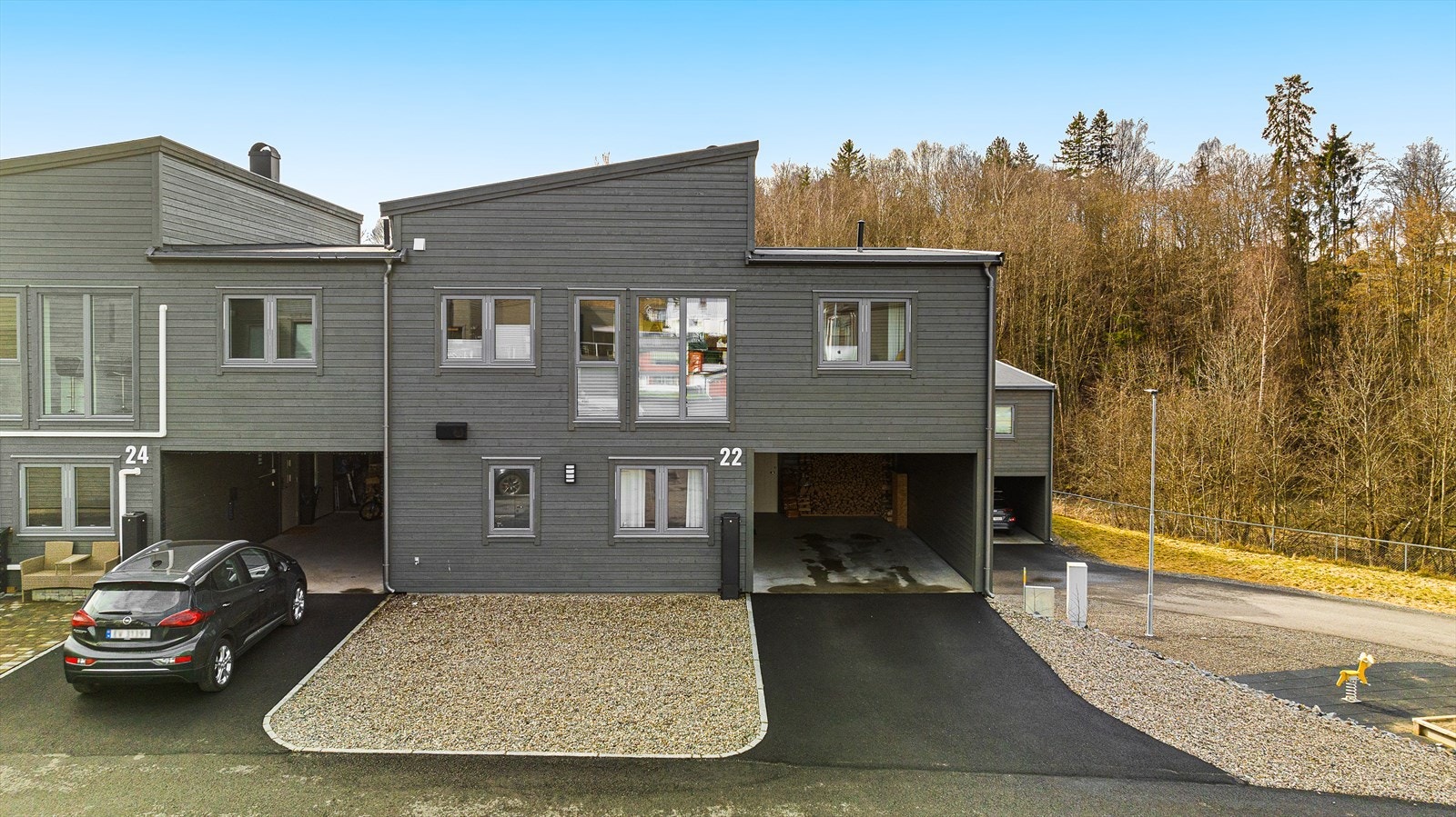Fasade. Den aktuelle eiendommen ligger på enden. Dyp carport med stor bod i enden. Galleribilde