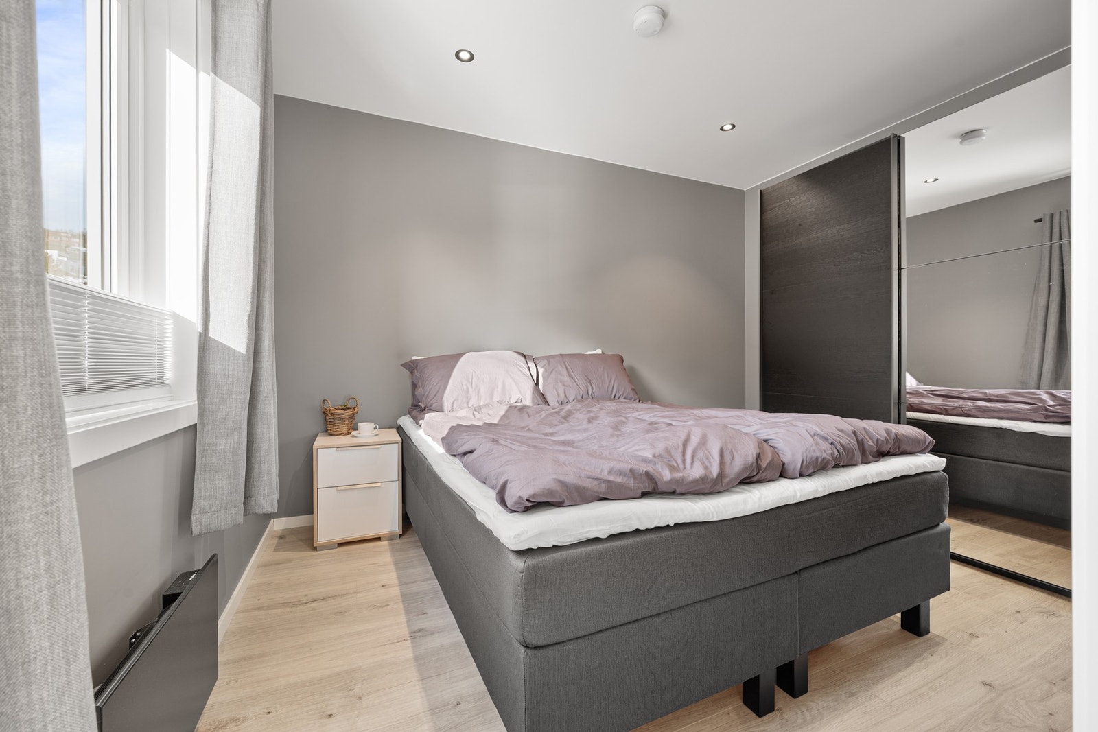 Stort soverom med innebygd skyvedørsgarderobe, downlights i tak og behagelige fargevalg Galleribilde