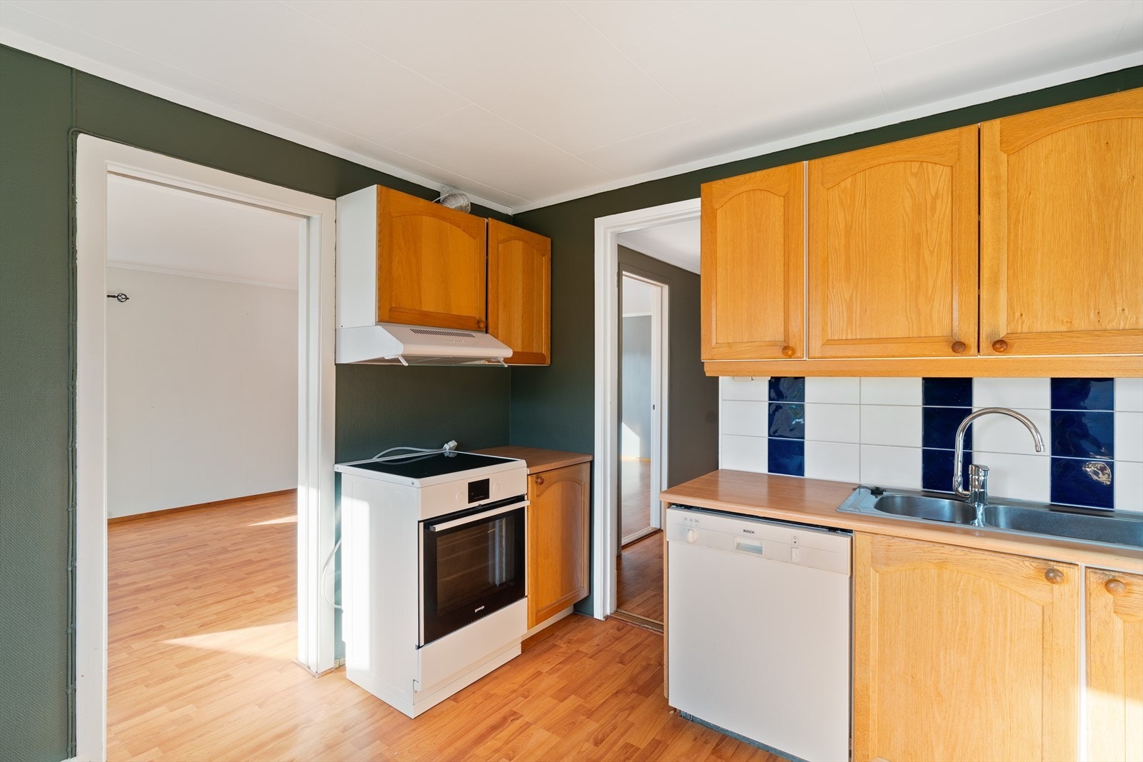 Kjøkkenet er i en furufarge med tilsvarende benkeplate. Her er det innredet med komfyr, servant, oppvaskmaskin og kjøleskap. Galleribilde