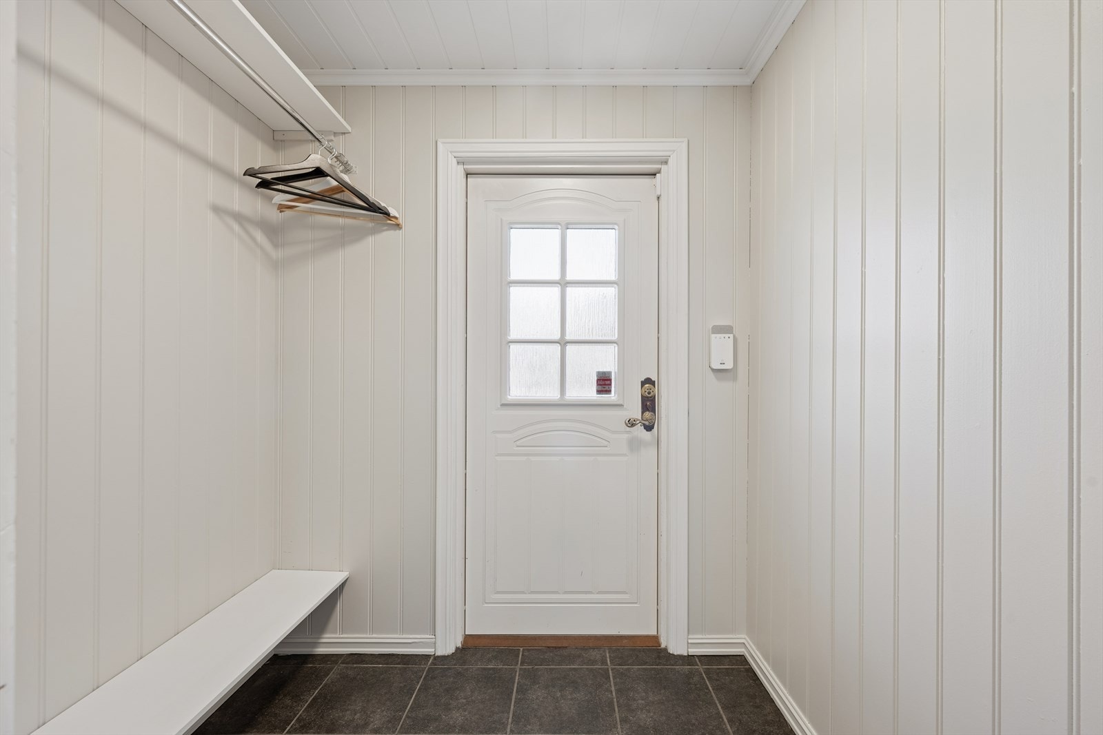 Entréen har flislagt gulv og plass til oppbevaring av yttertøy. Galleribilde
