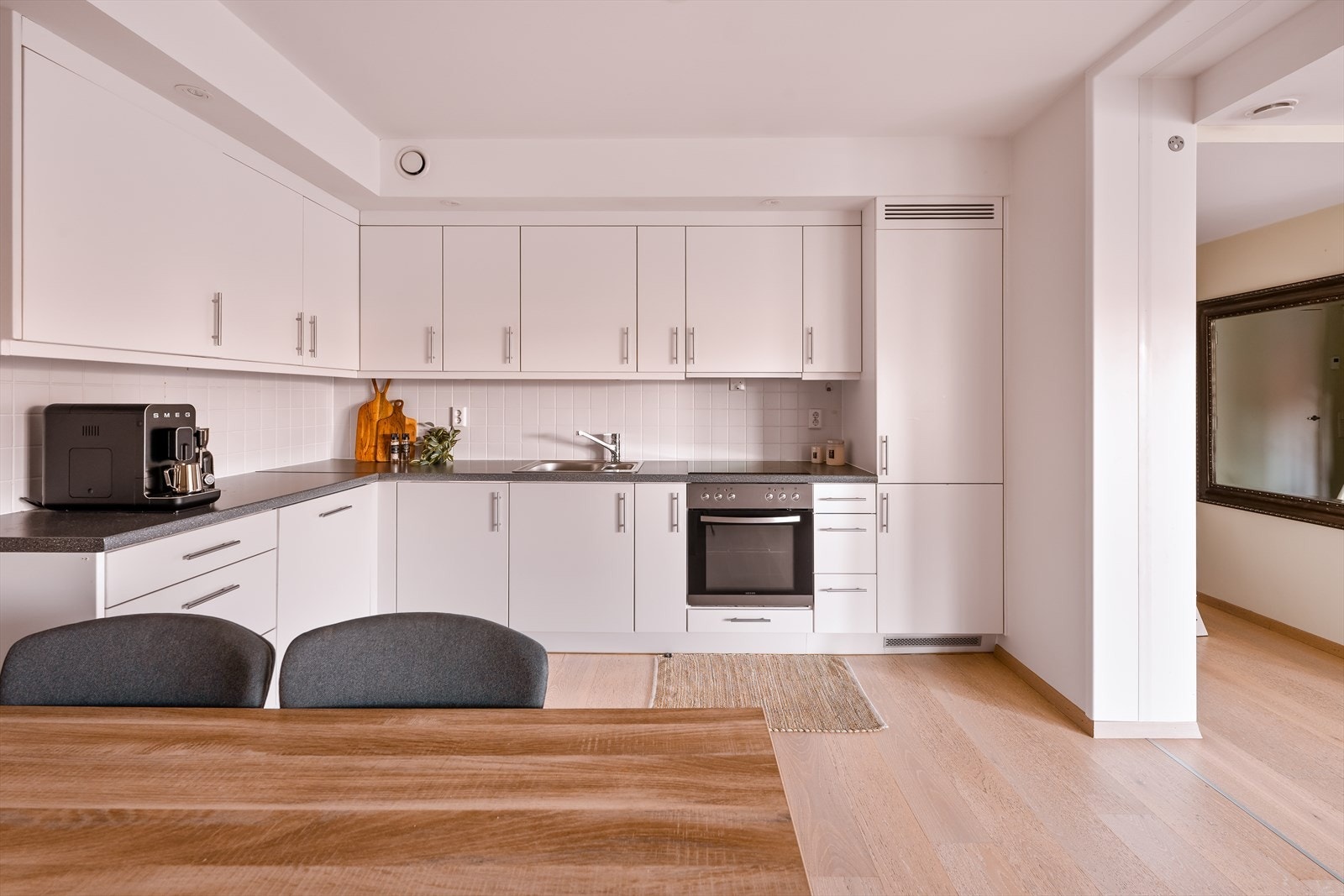 Lyst og pent kjøkken med integrerte hvitevarer. Det er godt med skap- og benkeplass. Galleribilde