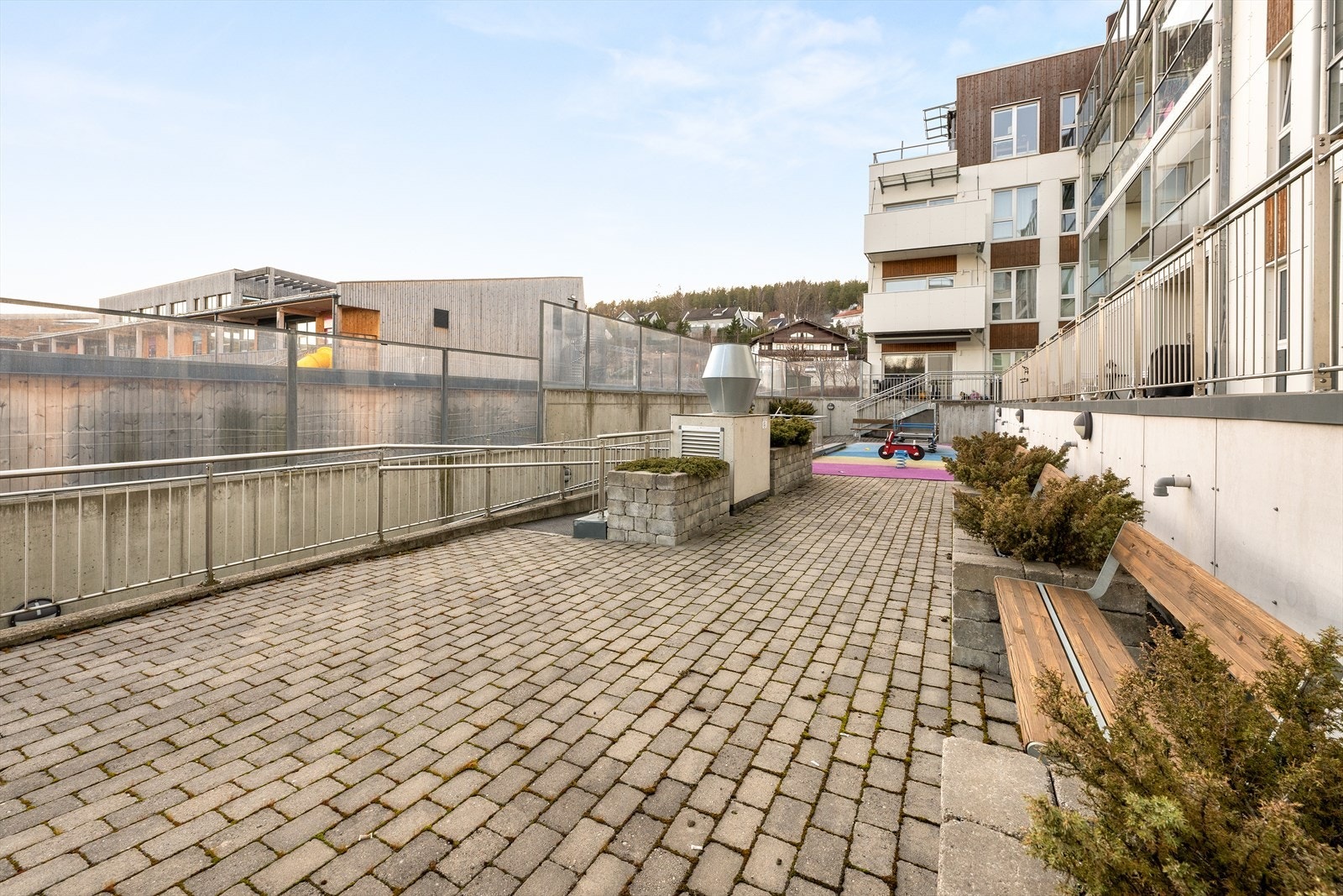 Fellestomten er pent opparbeidet med steinbelagte områder, frodige prydbusker og stemningsfull utebelysning. Det er lekestativer og sittebenker til felles anvendelse i bakgården. Galleribilde