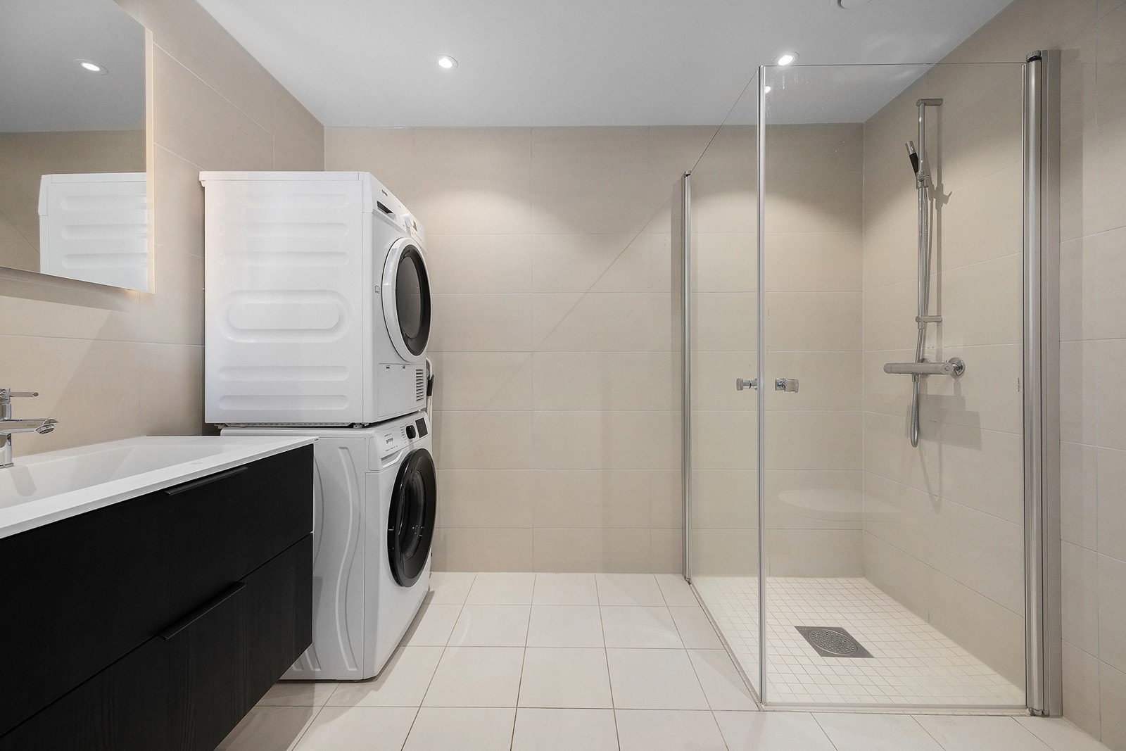 Badet er av god størrelse, og er innredet med dusjhjørne, toalett, servant, speil med belysning og opplegg for vaskemaskin. Galleribilde