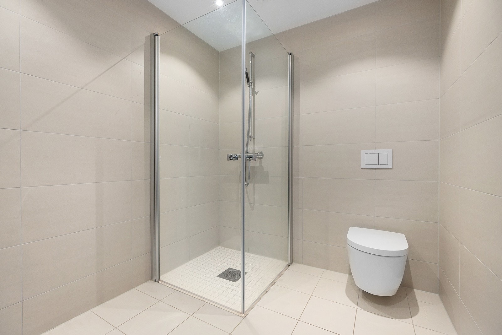Badet har en god og lun atmosfære med de varmbeige flisene. Galleribilde